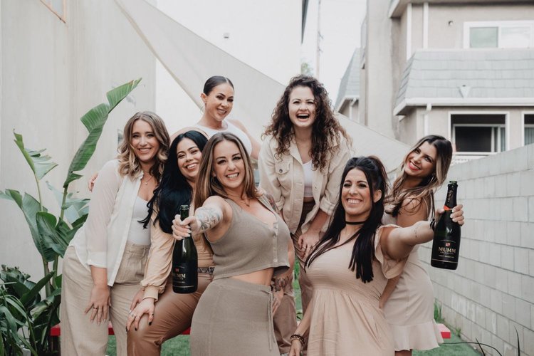 Seven colleagues celebrating outdoors with champagne