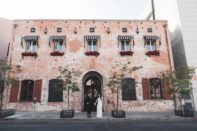 Couple standing in the brick courtyard entrance of Carondelet House
