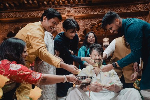 Close frame of relatives' hands during a Haldi ceremony