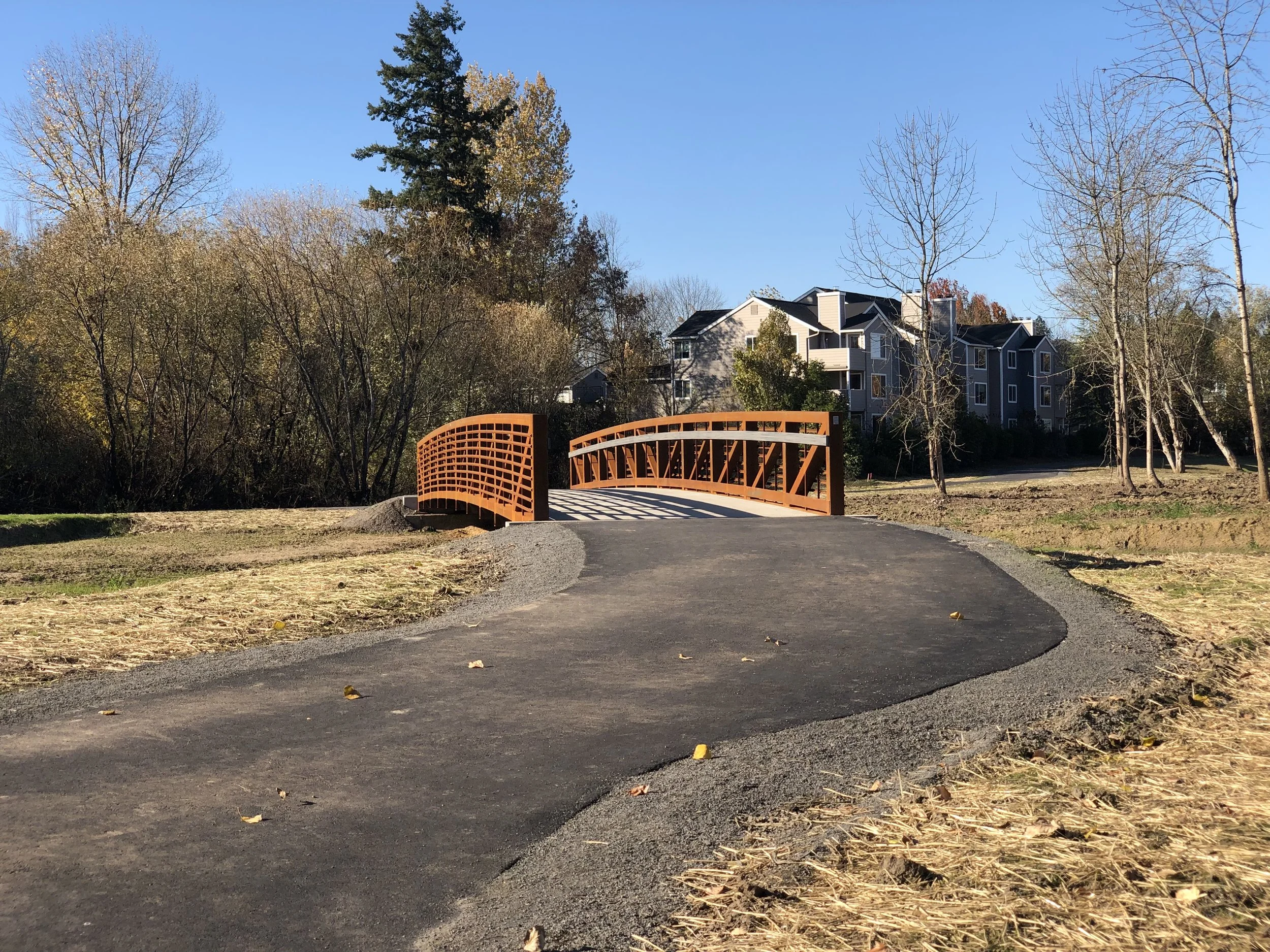 fanno Creek trail winding toward bridge over creek under construction