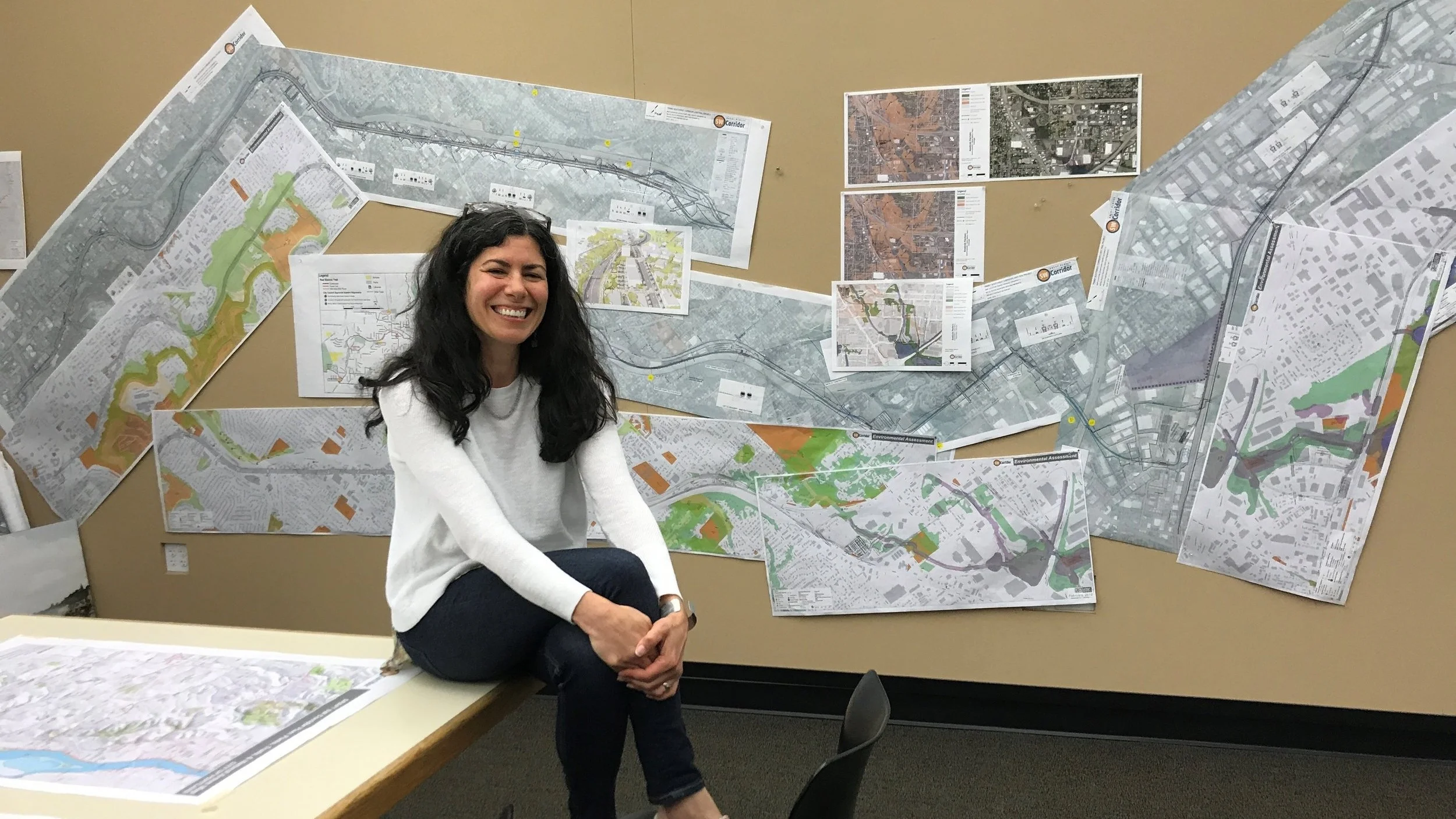 Jennifer D’Avanzo in front of SW Corridor plans that take up an entire wall at GreenWorks HQ