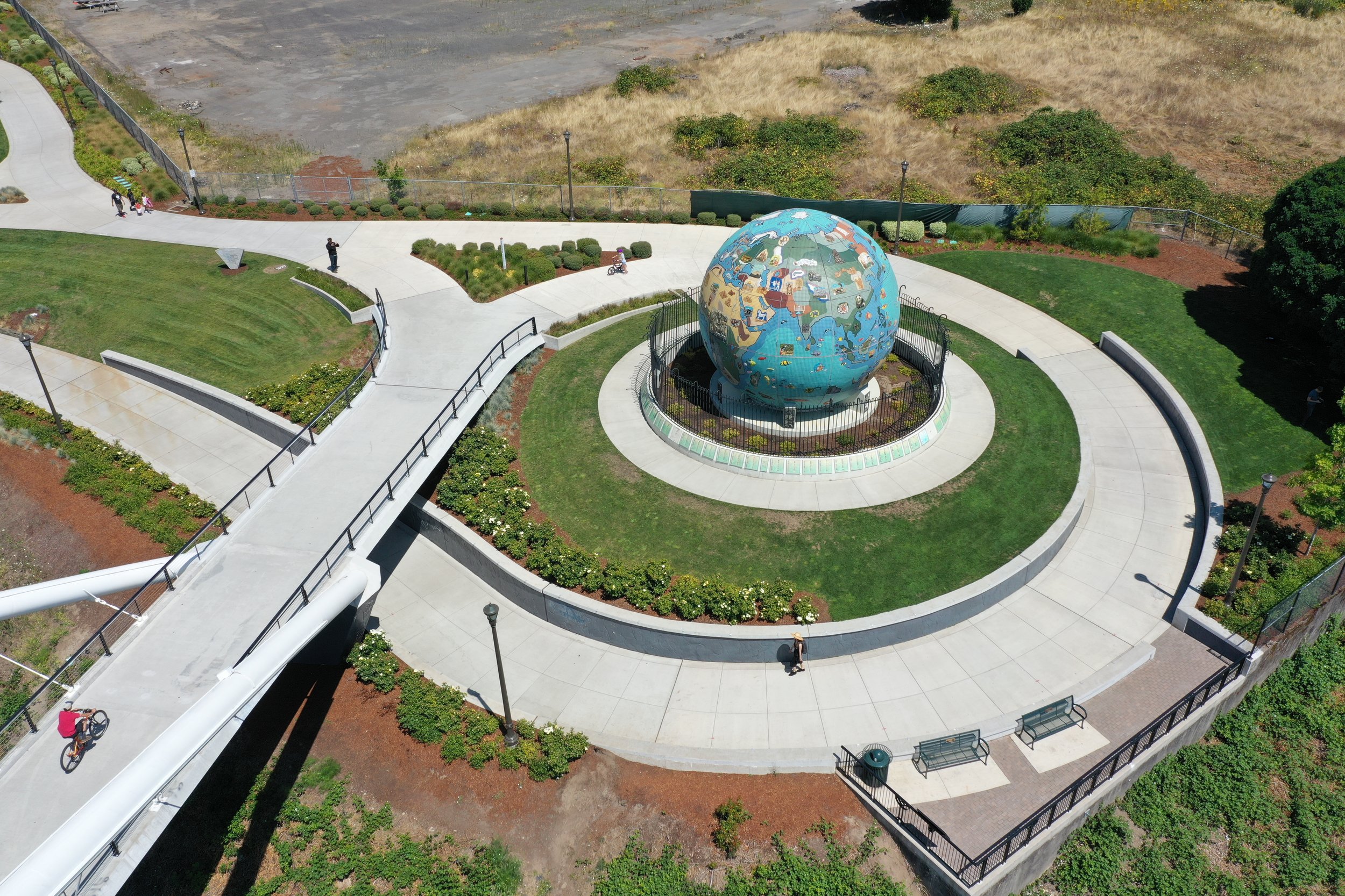 globe in site design with grass and sidewalks and a bridge footing