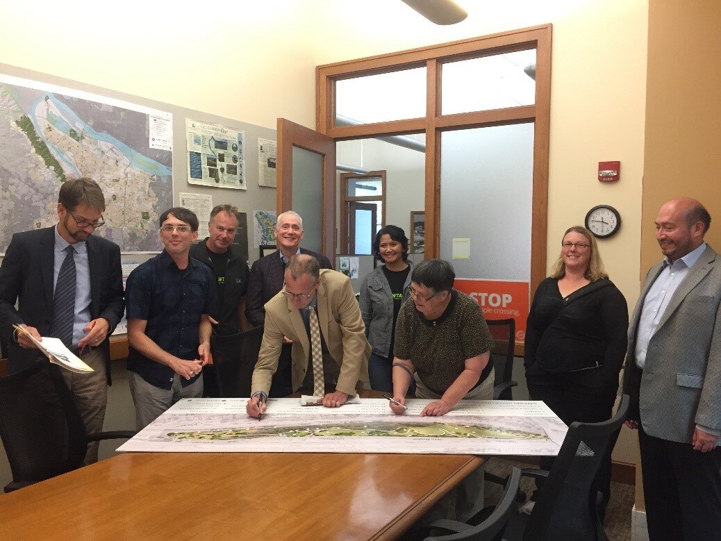 Portland City Commissioner Nick Fish signing plans for Gateway Green, alongside project champion Linda Robinson