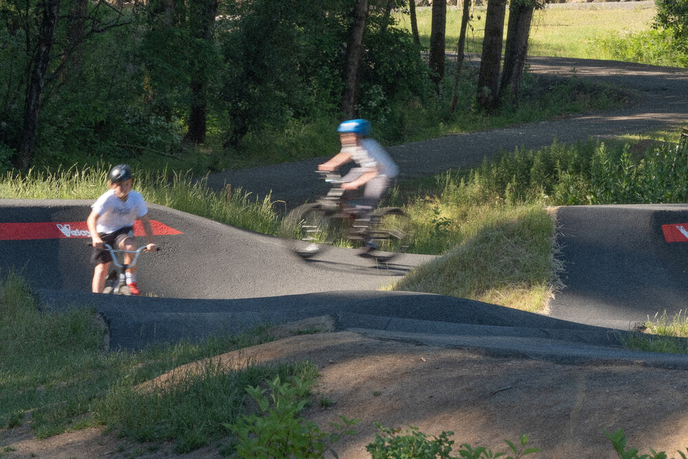Kids ride the Velosolutions Pump Track at Gateway Green