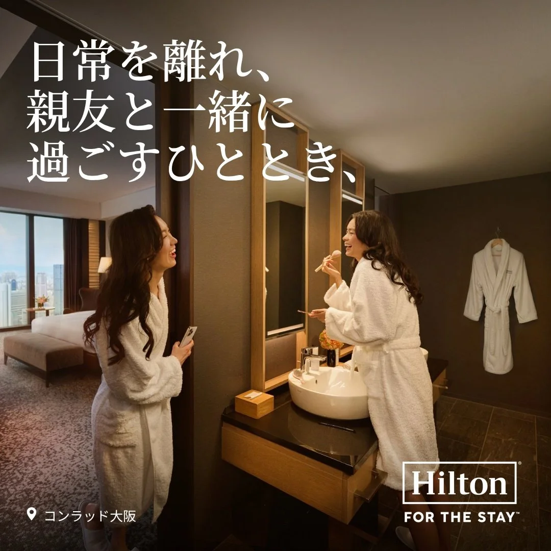 Two friends in bathrobes in a suite at Conrad Osaka, Hilton hotel photography in Japan