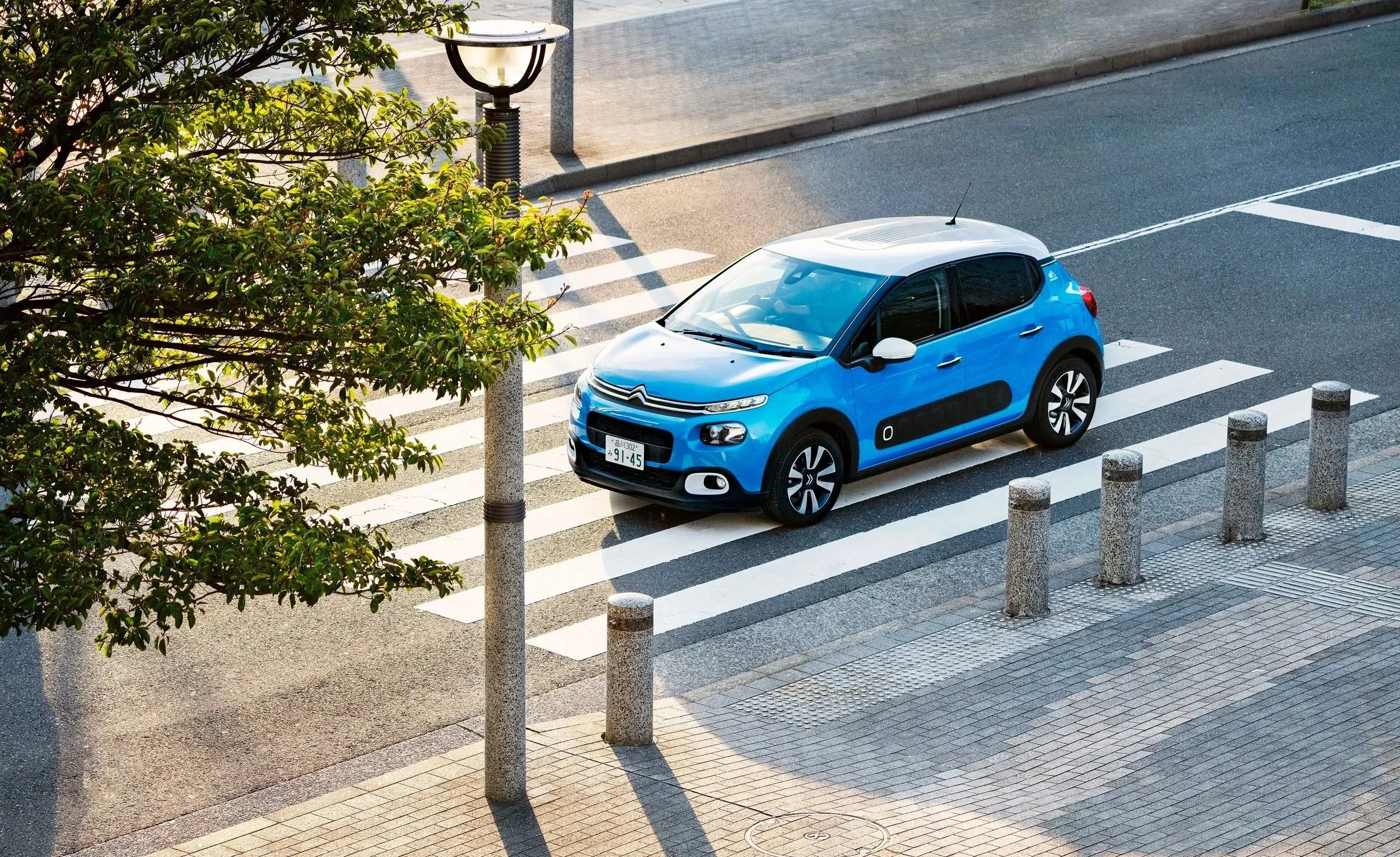 Citroën car photography of a blue hatchback at a city crossing
