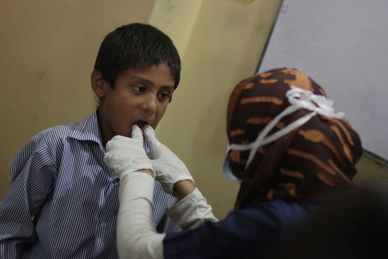 Dr. Razzak conducting an oral exam during Barkat's free health camp conducted at Rising Star School for underpriviledged children in Lahore.