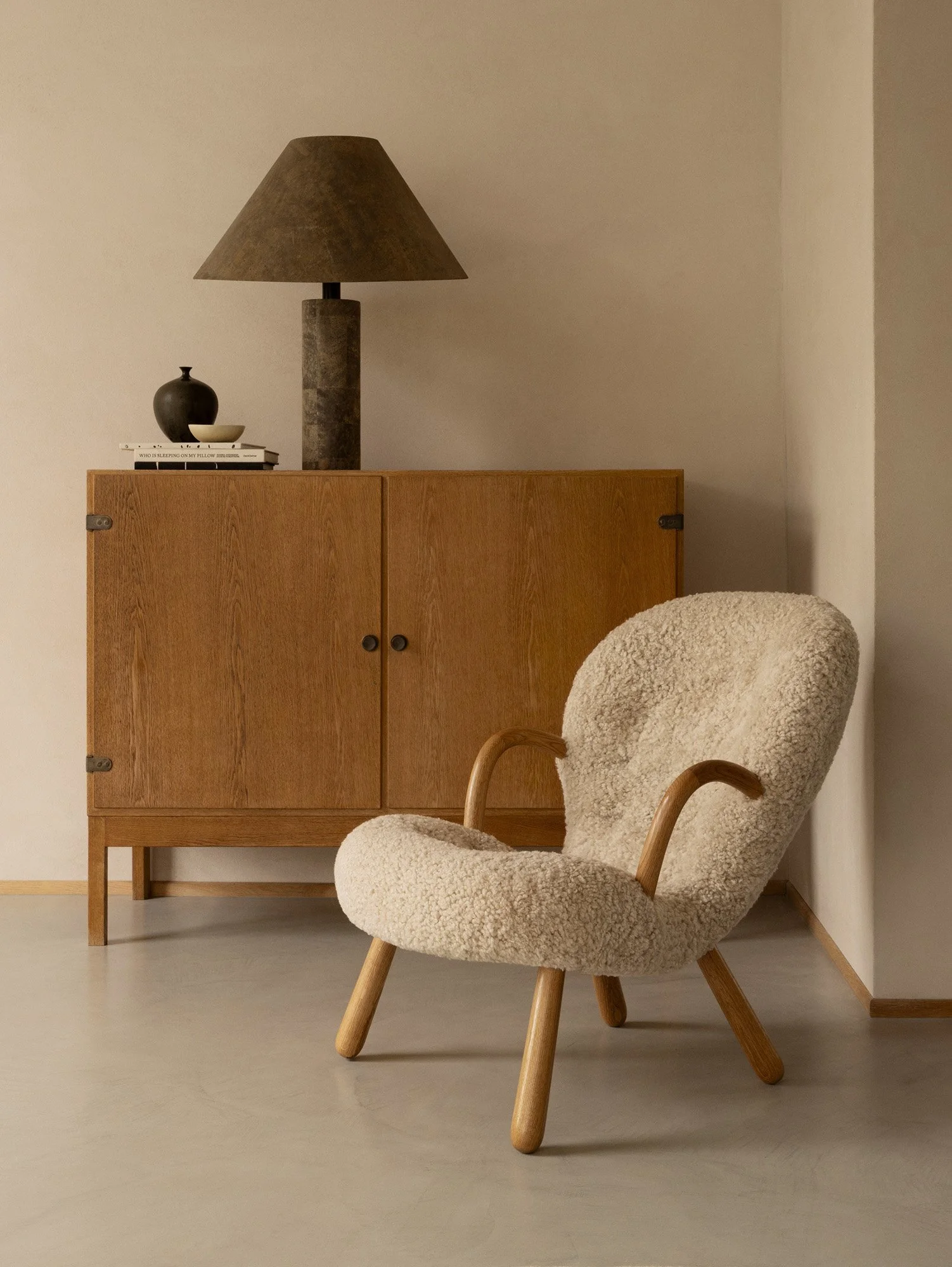Arnold Madsen's Dagmar clam chair in maple wood with cream sheepskin upholstery, featuring a sculptural shell-like form