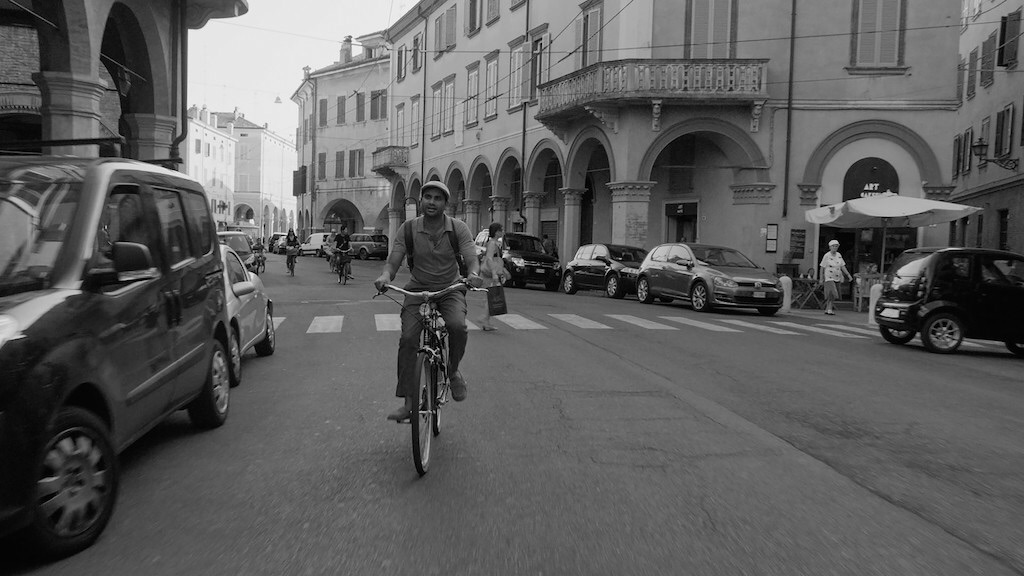 Aziz Ansari riding on bike through italy