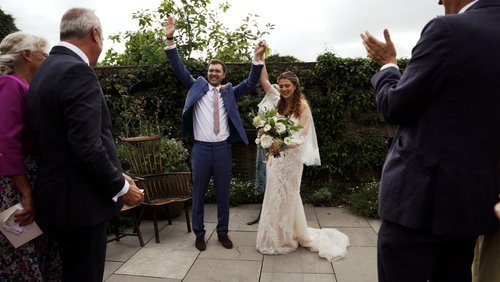 Bride and groom celebrating their vows in front of crowd on wedding day