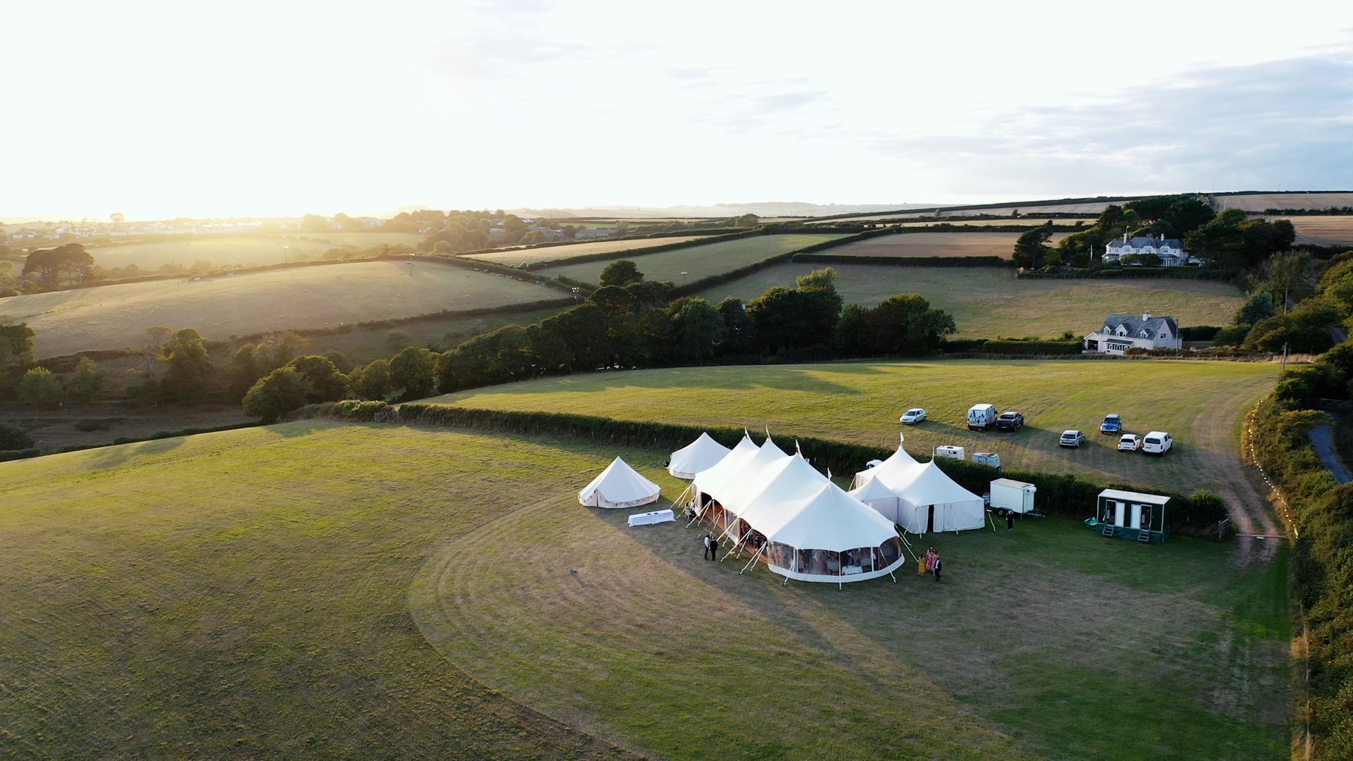 Aerial videography of large white marquee in Devon country field