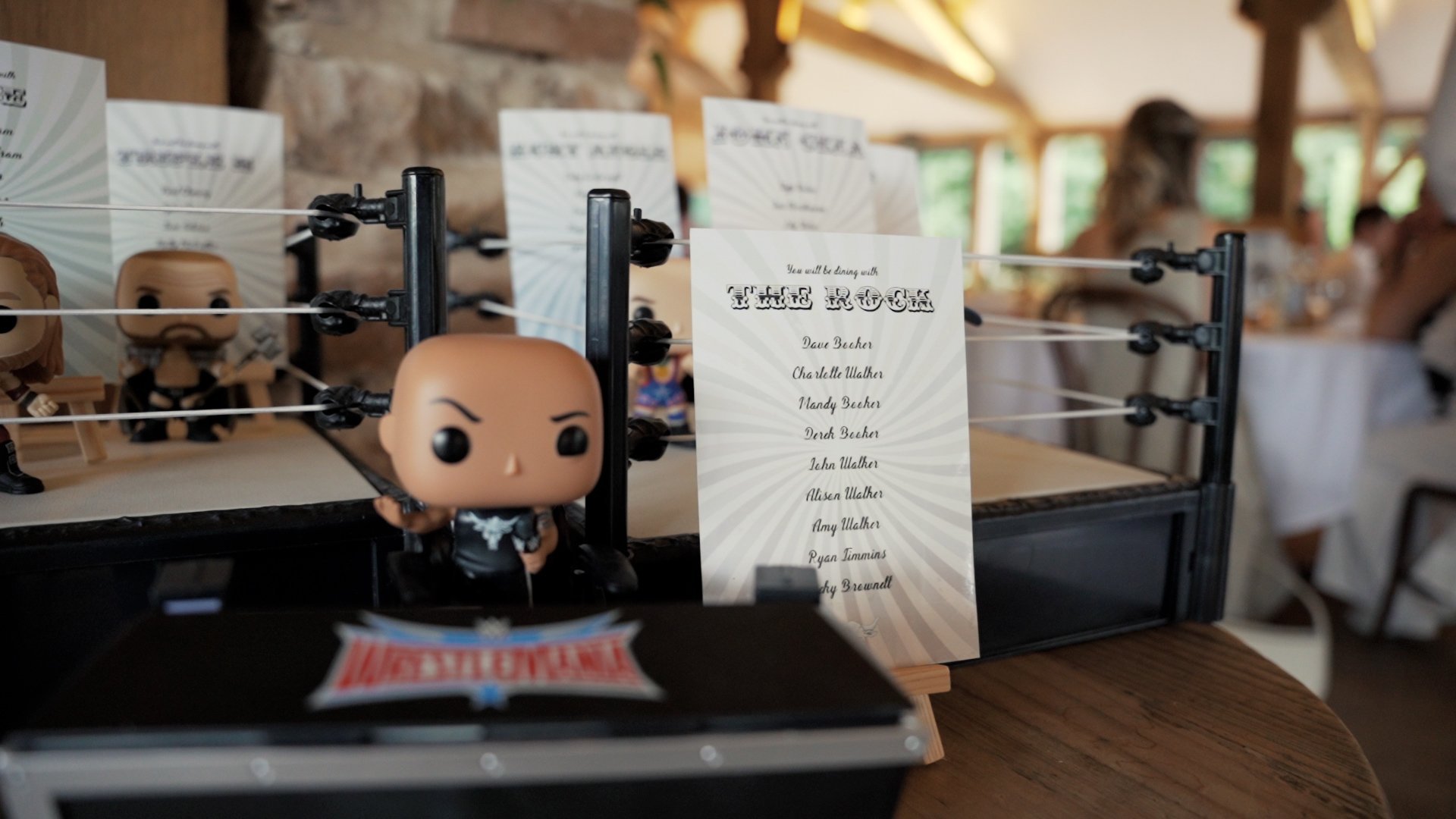 Table plans and layouts printed onto white paper and arranged inside a mini wrestling ring for WWE themed wedding reception