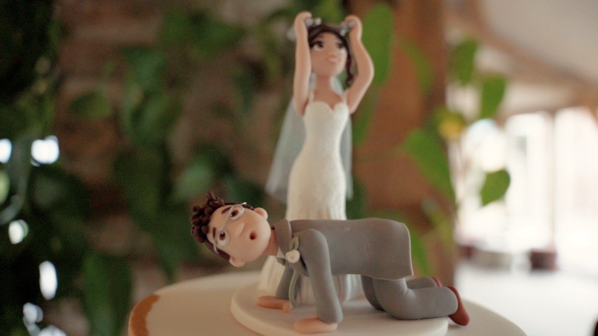 Wrestling wedding cake topper of a bride smashing a chair of Groom's back