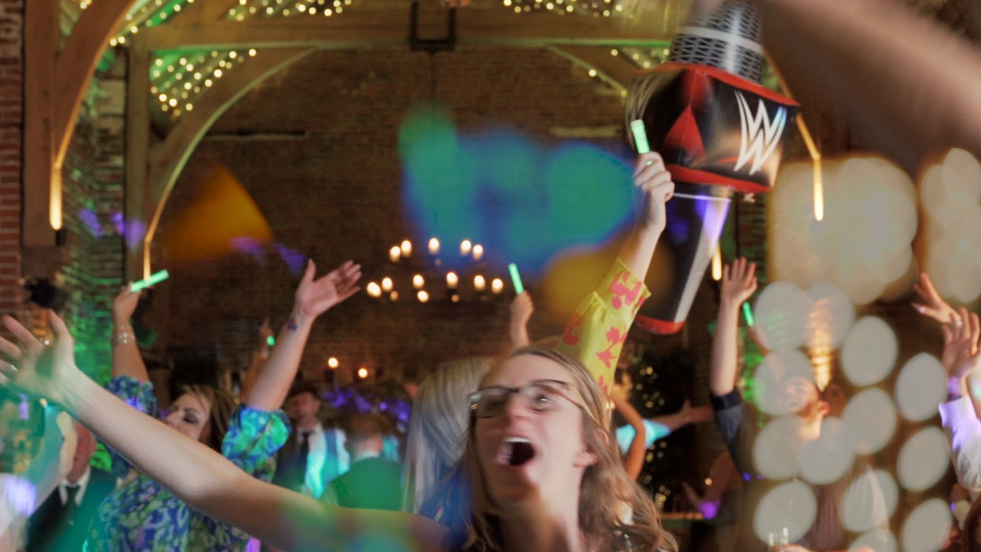 Wedding guests dancing inside a beautiful wedding venue at a wrestling-themed wedding reception