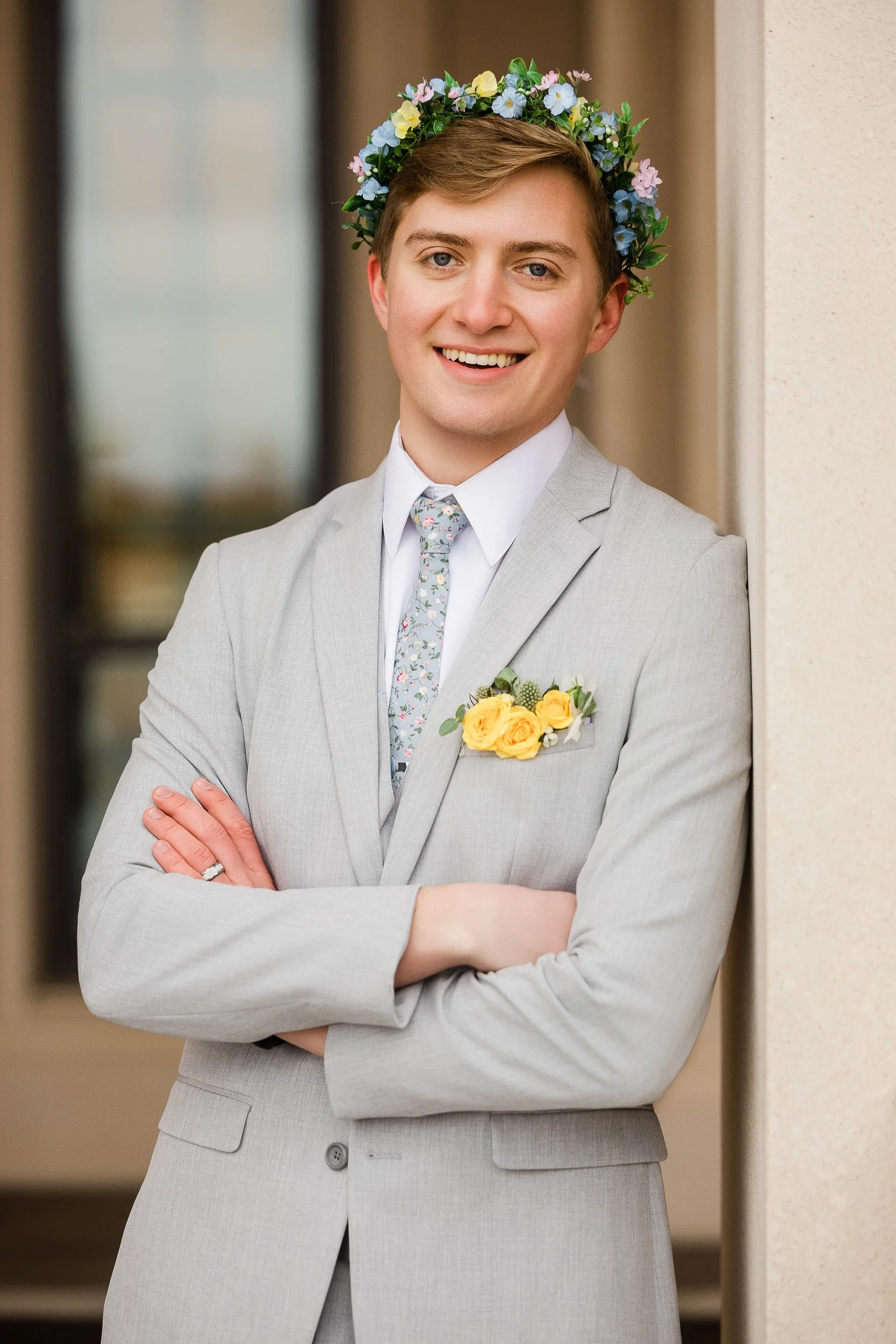 Groom wearing a floral crown poses for a formal portrait after a wedding at the LDS Temple in Fort Collins, Colorado