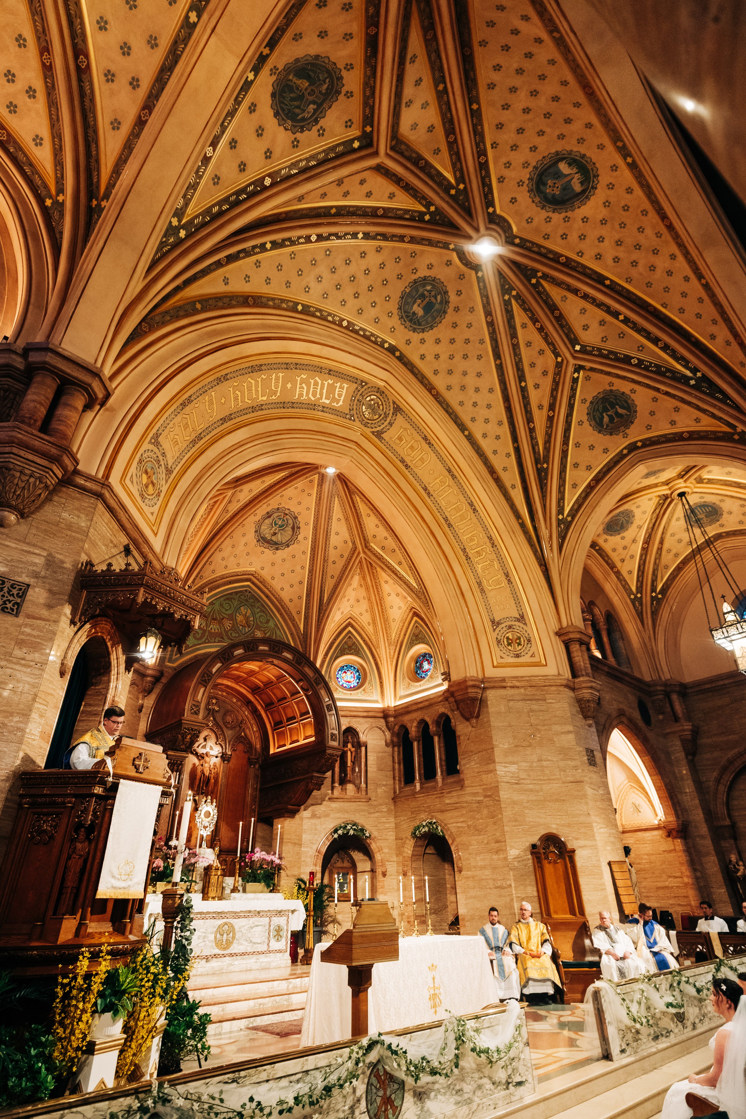 A tall and wide view of father's remarks during a nuptual mass at Holy Ghost Catholic church in Denver, Colorado