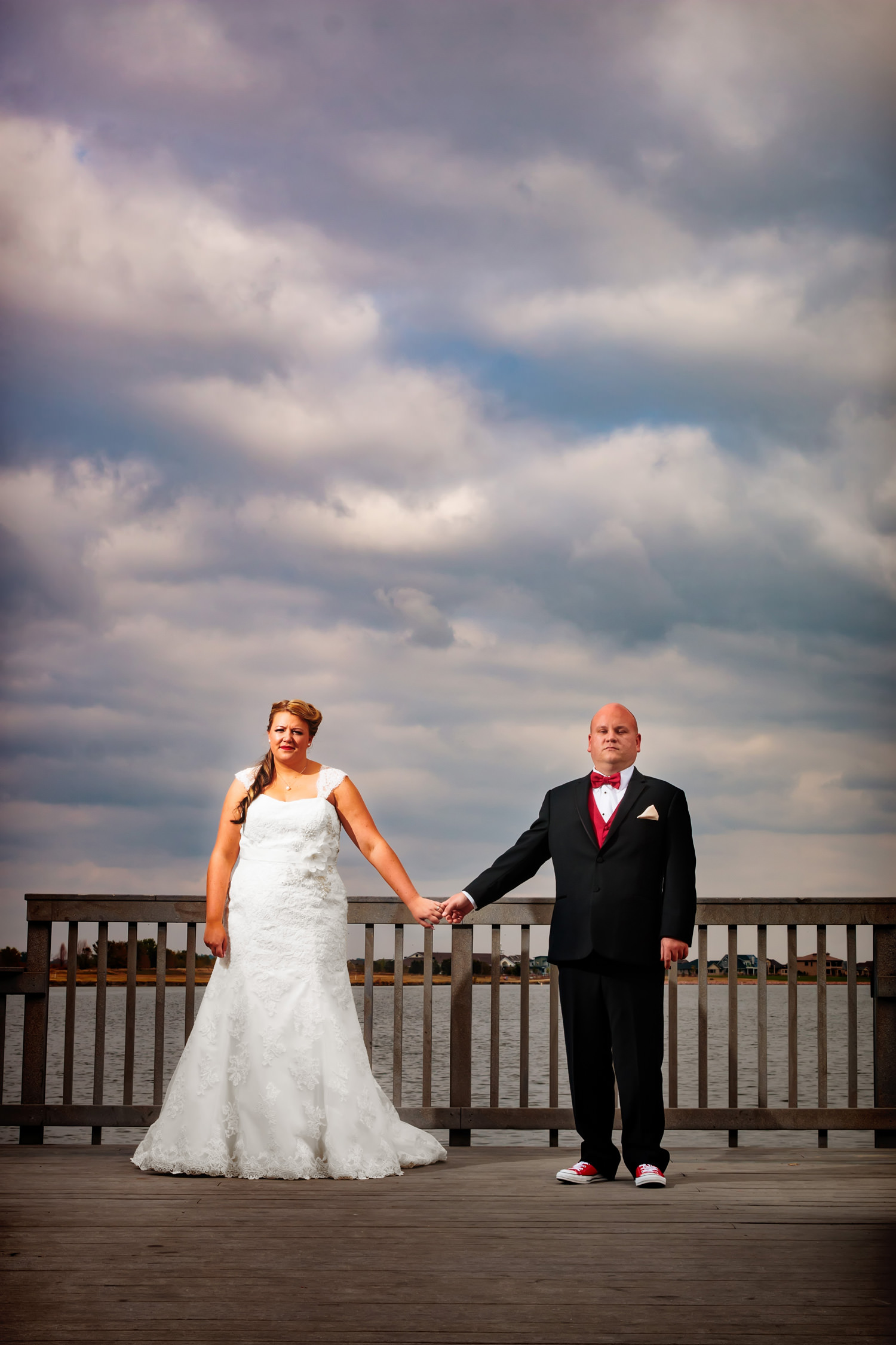 bride and groom relax in a down moment on a lake dock as capture by tomKphoto, windsong estate wedding photographer