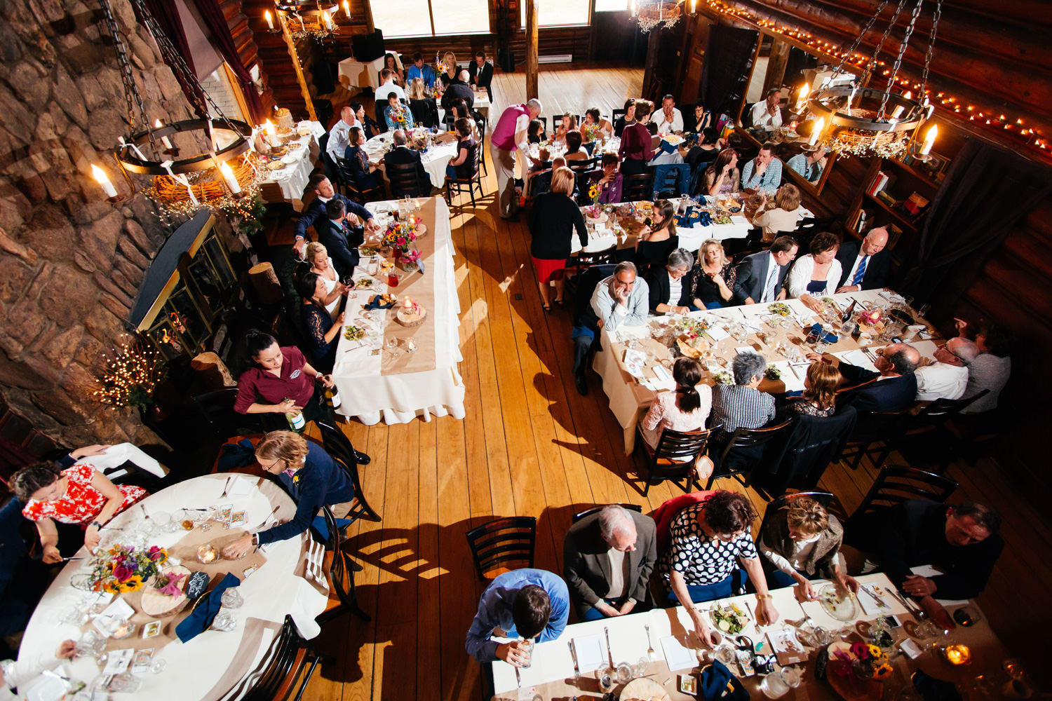 over 100 guests enjoy a reception feast during a twin owls steakhouse wedding in estes park, colorado