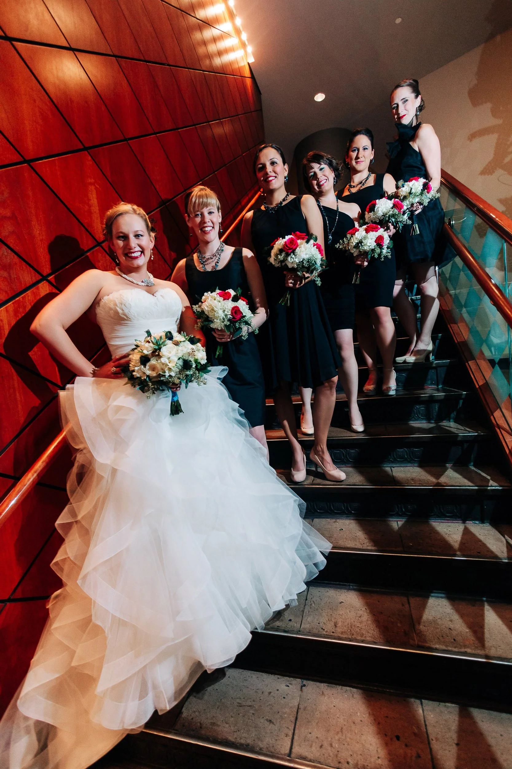 Bride and her bridesmaids stop for a formal photo during a Magnolia Hotel wedding in Denver, Colorado