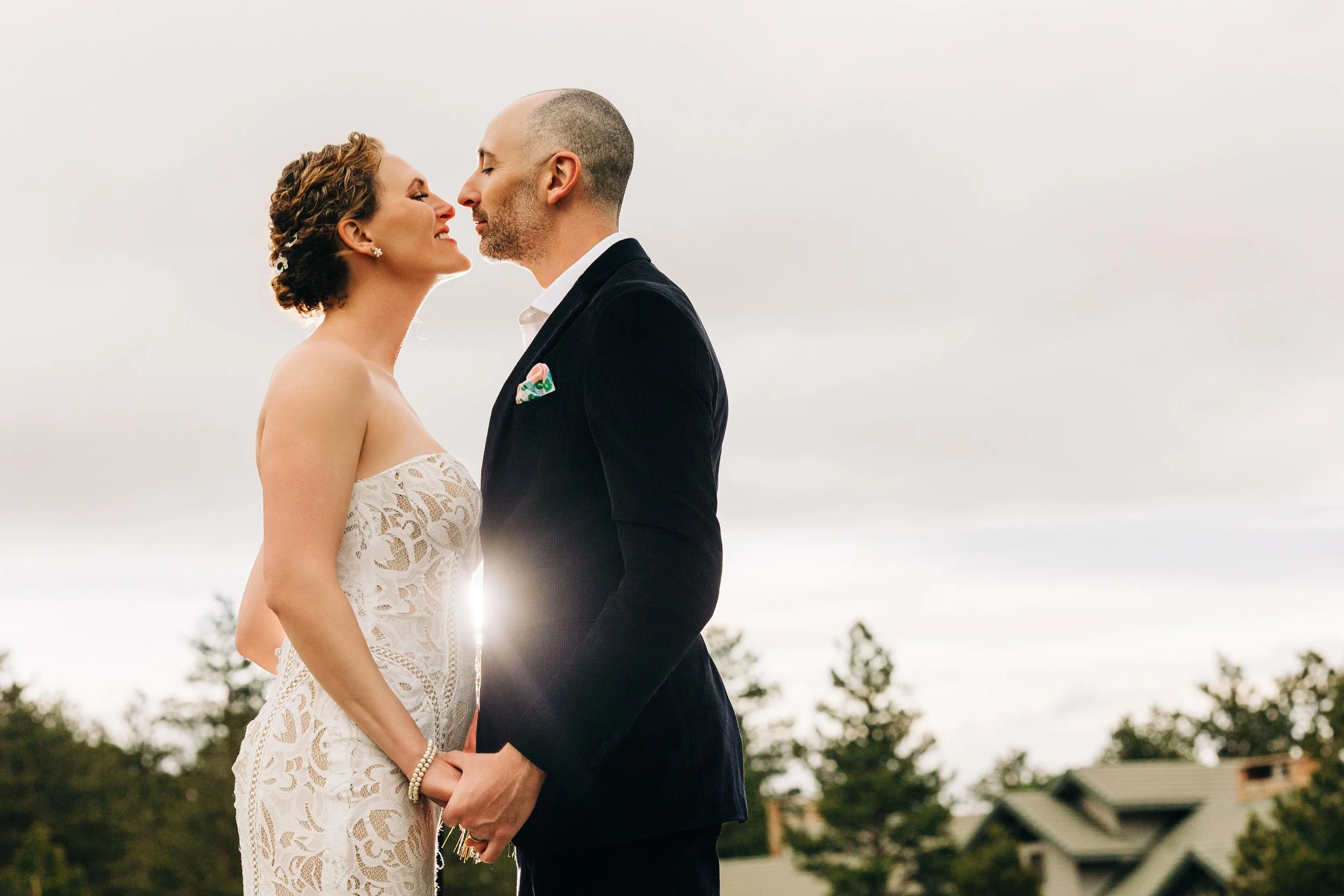 A bride and groom come in close for a kiss during a Black Canyon Inn wedding reception in Estes Park, Colorado