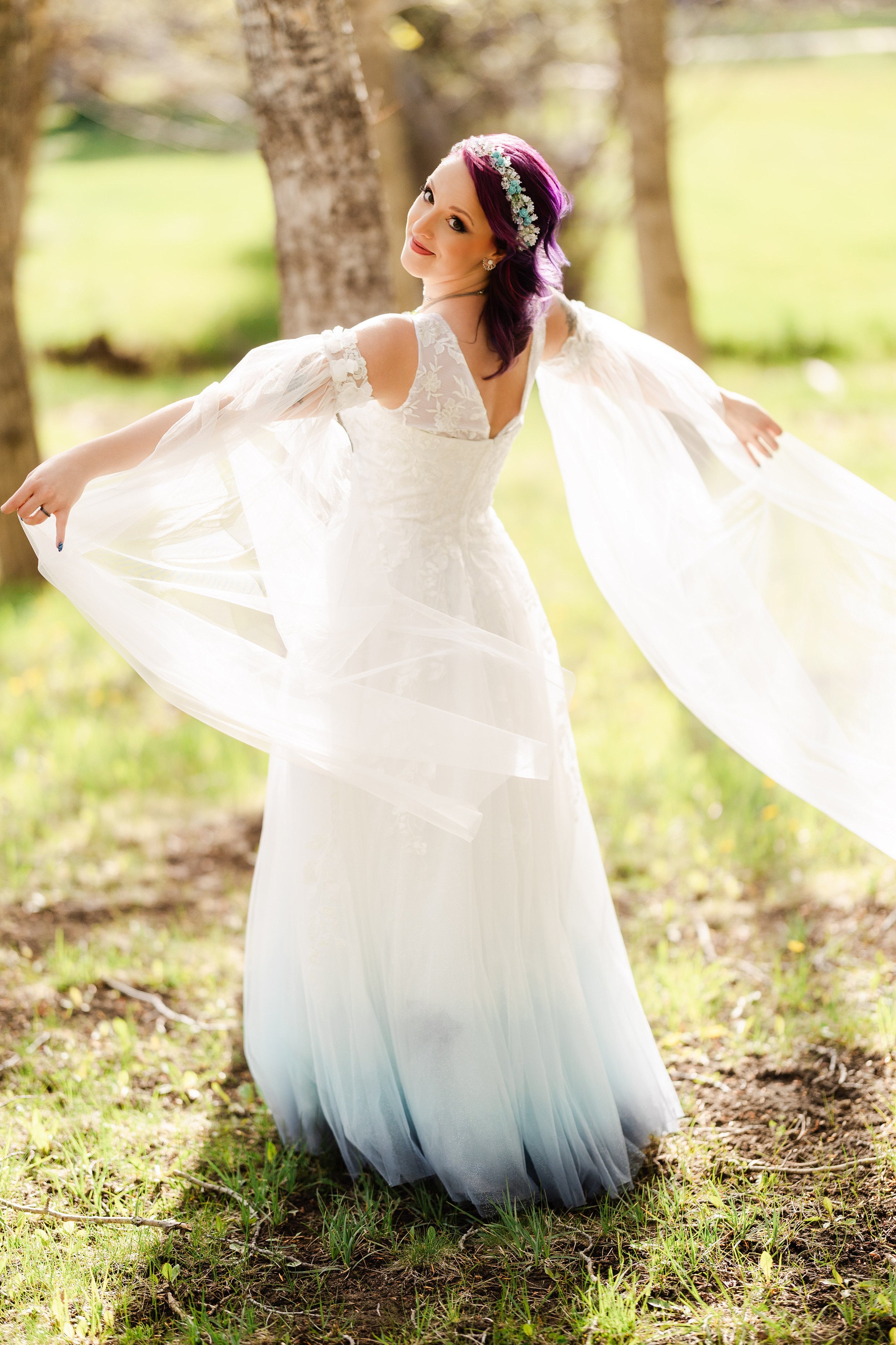 A bride with dyed purple hair and lace sleeves spins after a wedding at Black Canyon Inn in Estes Park, Colorado