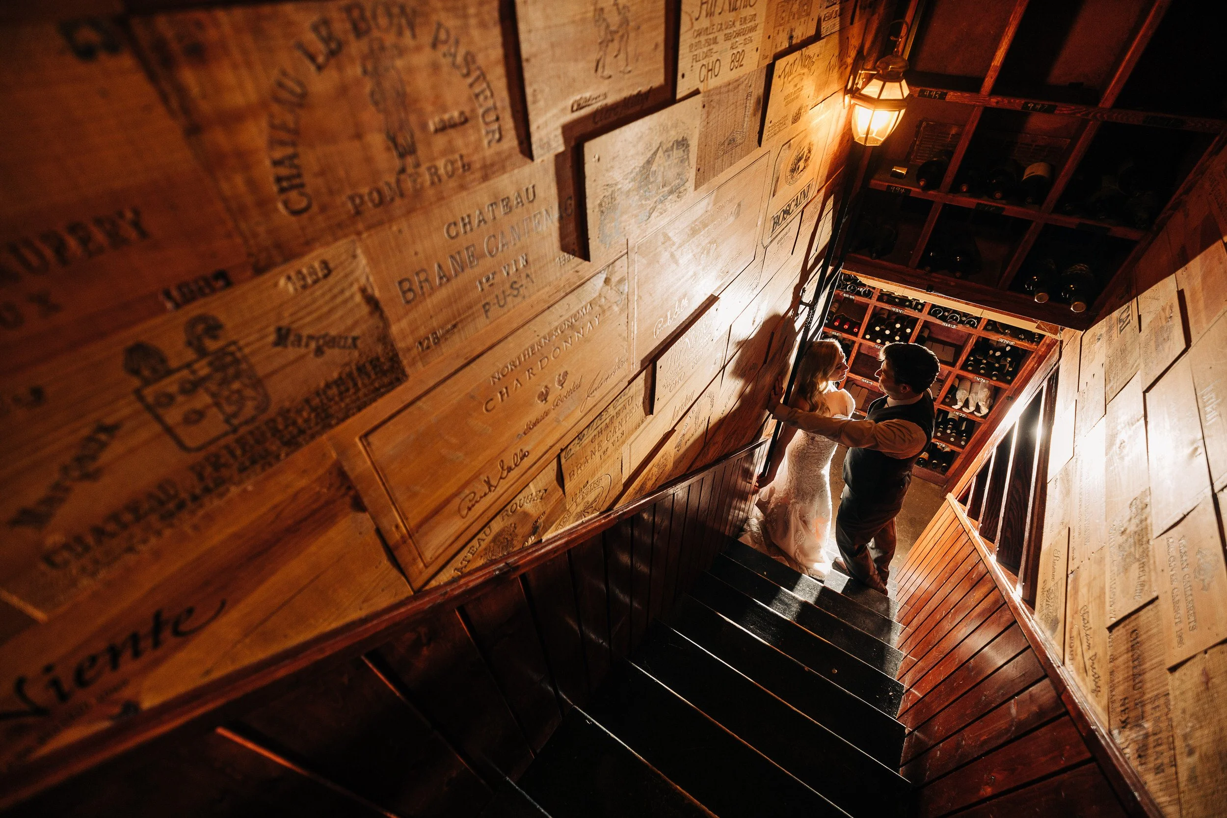 A bride and groom sneak away for a quiet romantic moment in the wine cellar of the Greenbriar Inn in Boulder, Colorado