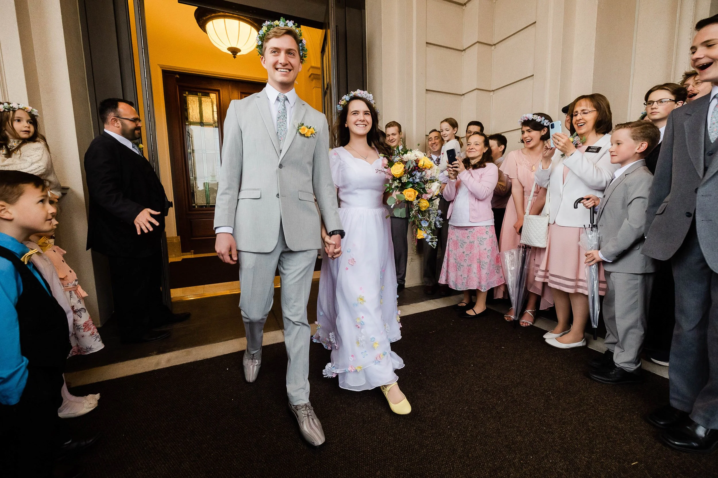 A wedding couple emerges from The LDS Temple in Fort Collins, Colorado after their sealing.
