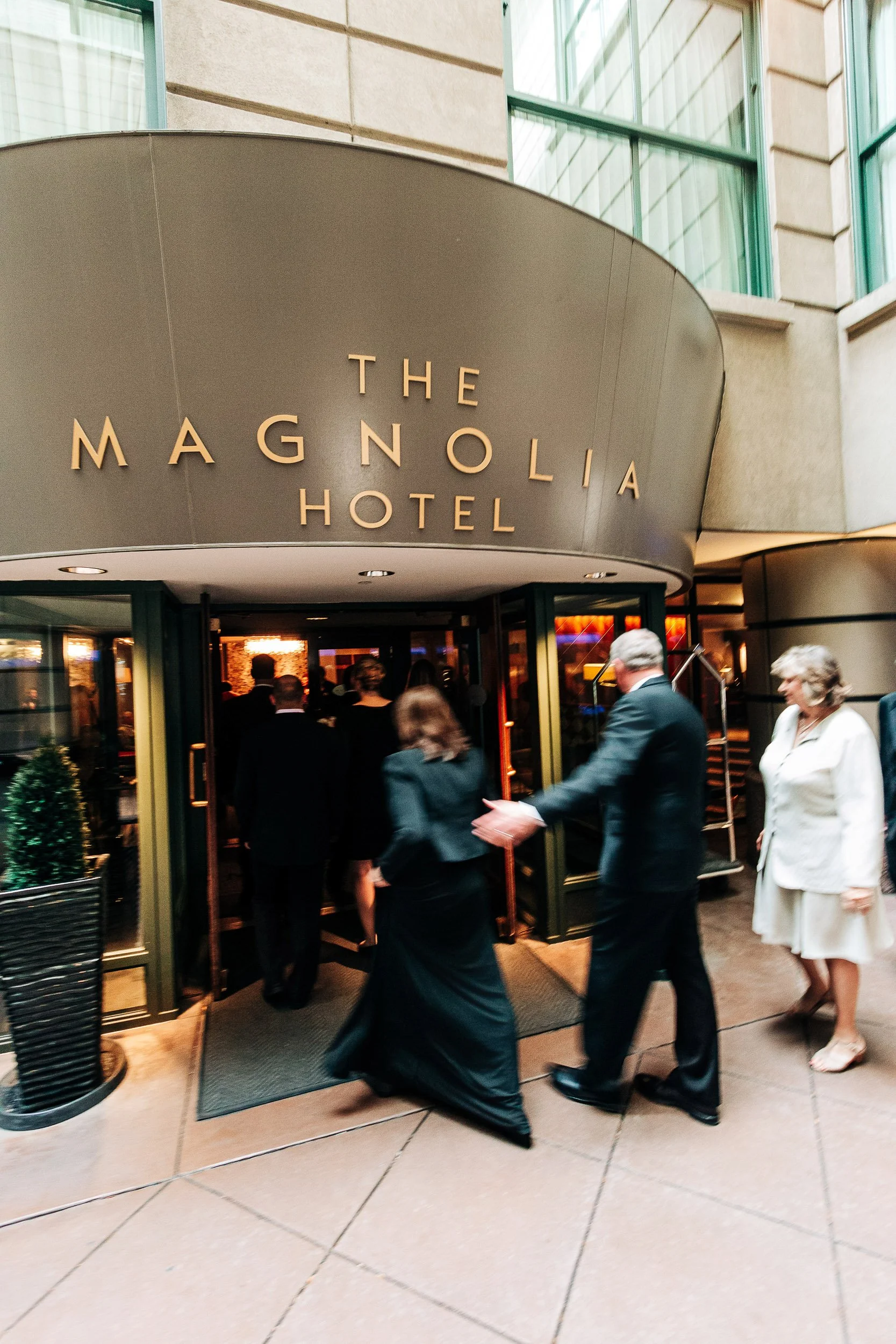 Guests walk though the exterior rotating door during a Magnolia Hotel wedding in Denver, Colorado
