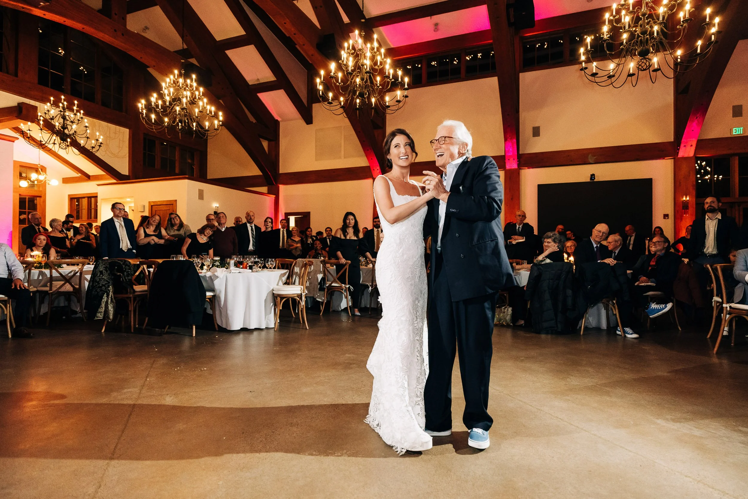 Bride and father laugh while dancing together during a Donovan Pavilion wedding reception in Vail, Colorado