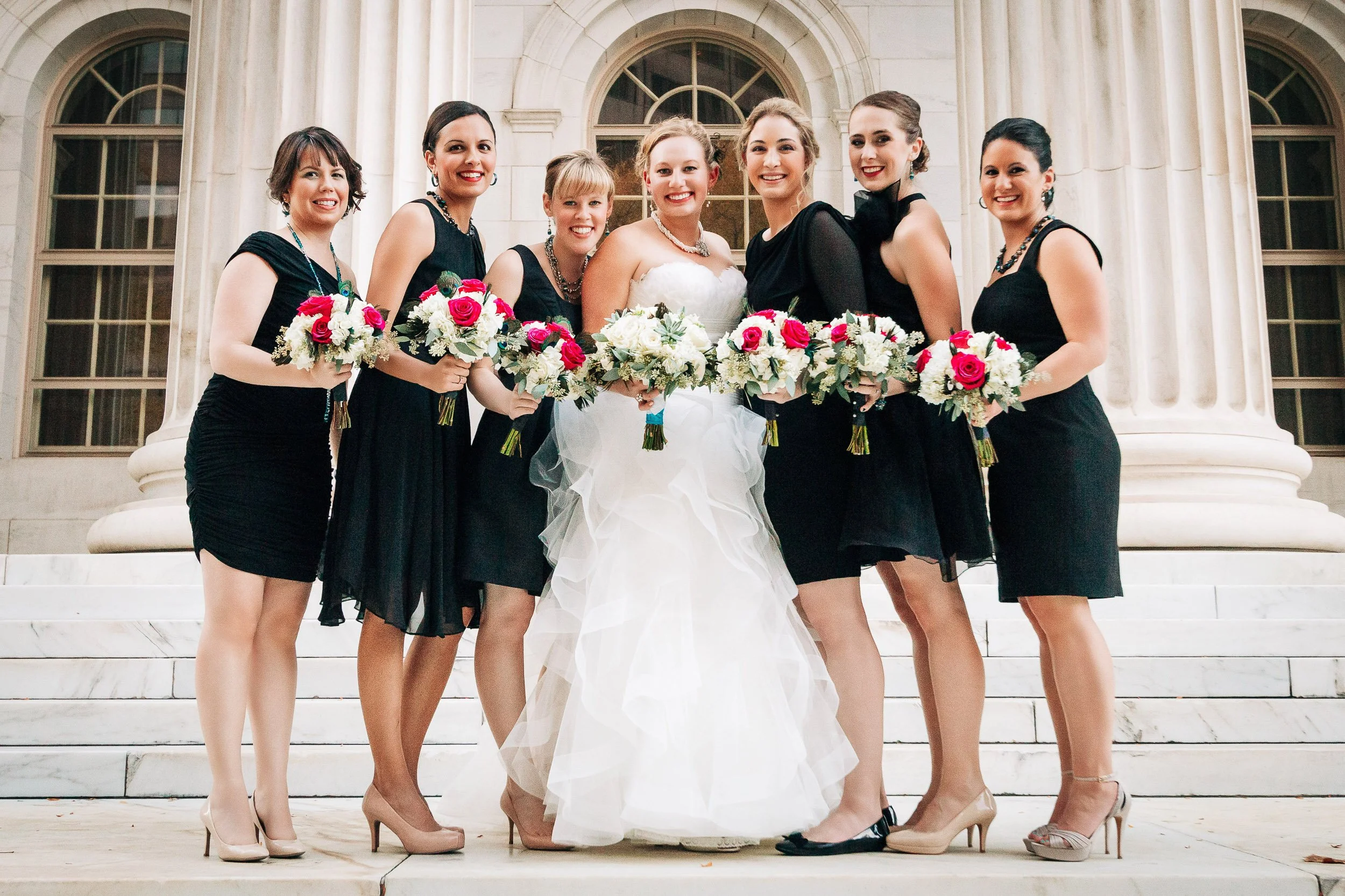 Bride and her bridesmaids hug together on the street during a Magnolia Hotel wedding in Denver, Colorado