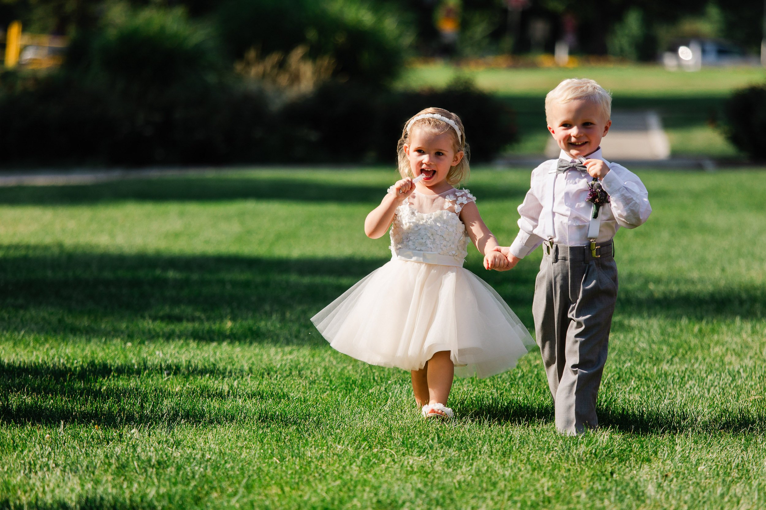 Ring bearer and flower girl blow bubbles during a Washington Park Boathouse wedding in Denver, Colorado