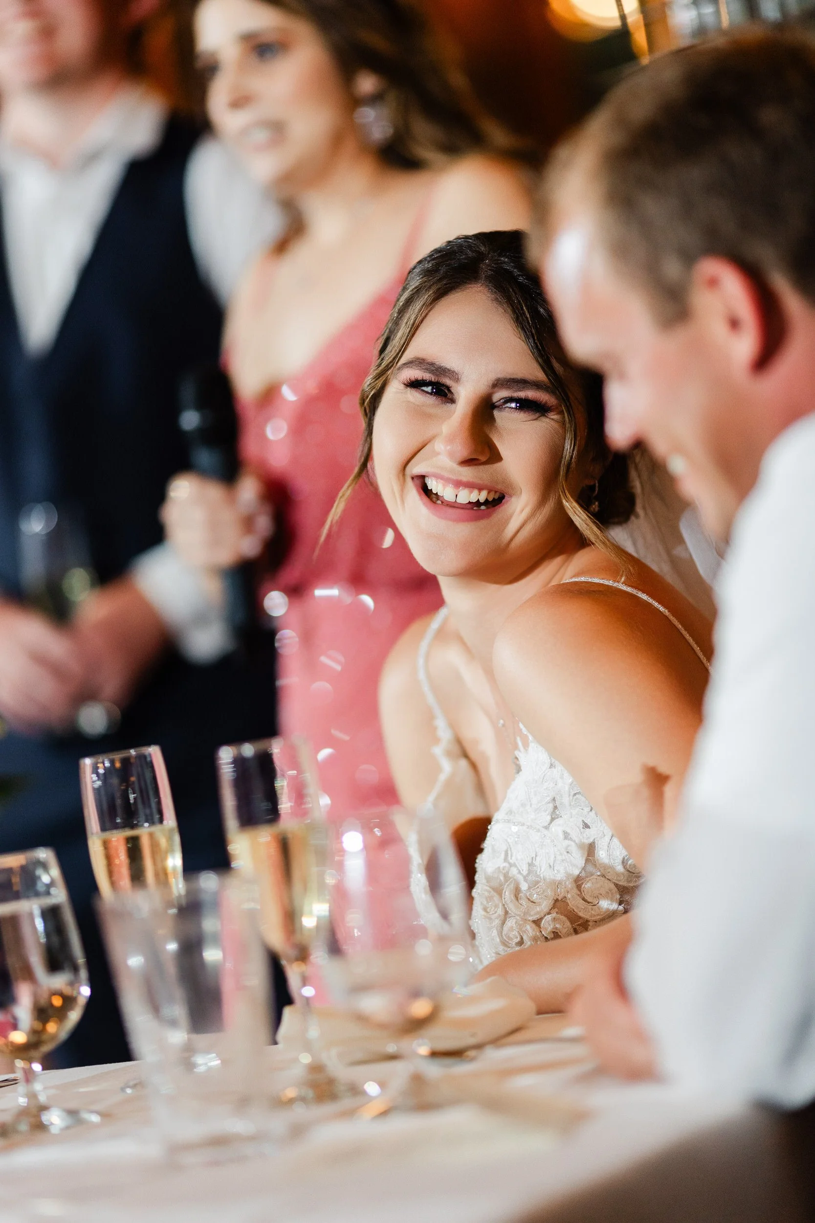 Bride reacts to the gentle teasing she's receiving during her sister's speech during a Greenbriar Inn wedding reception in Boulder, Colorado