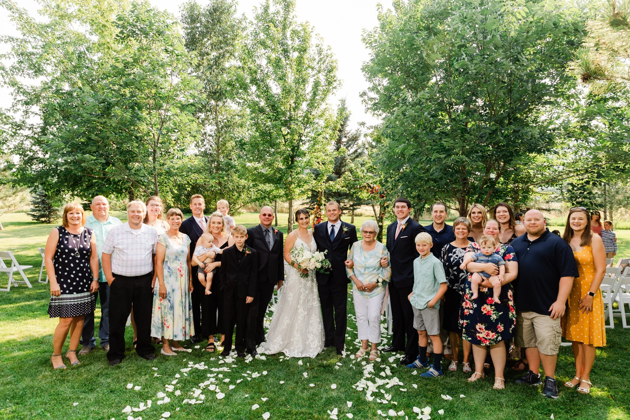 Large family group poses for photographer during a Summer Greenbriar Inn wedding in Boulder, Colorado