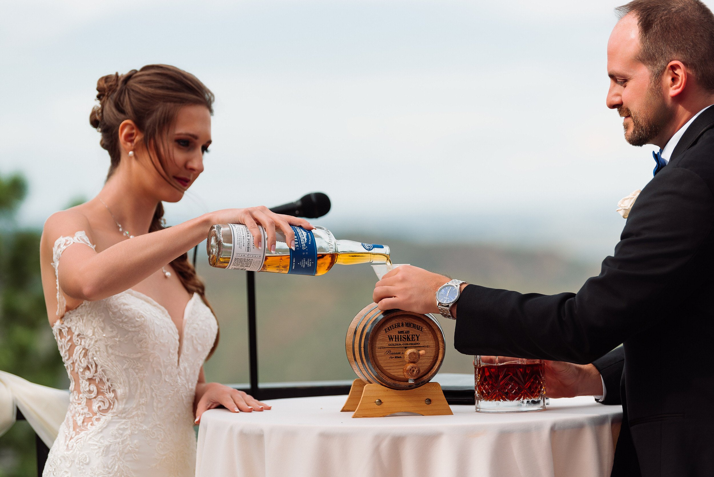 Bride pours whiskey into a ceremonial barrel during a Mount Vernon Canyon Club in Golden, Colorado.