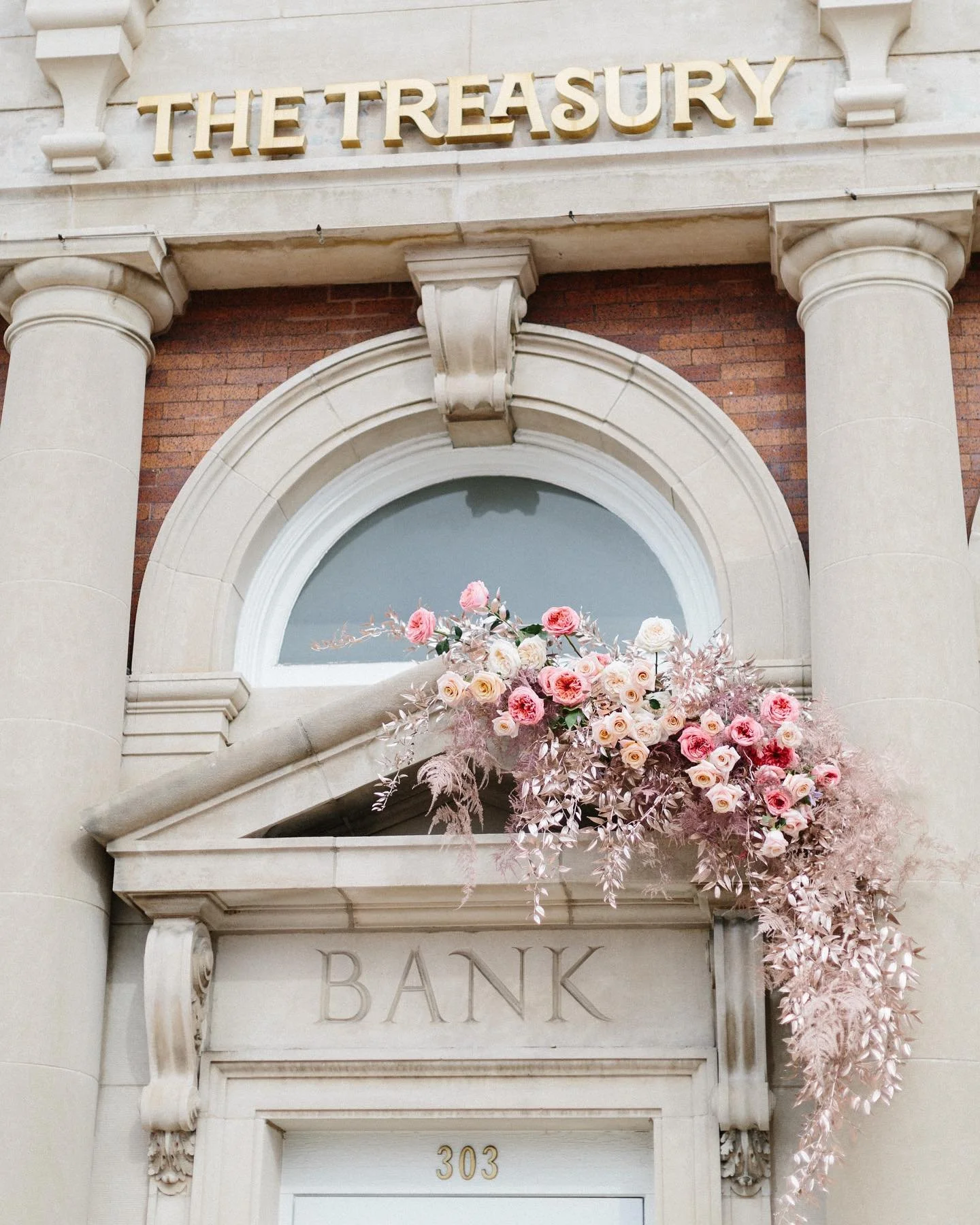 Entrance of The Treasury historic wedding venue in Delavan Wisconsin featuring the original bank facade and floral wedding ceremony installation.