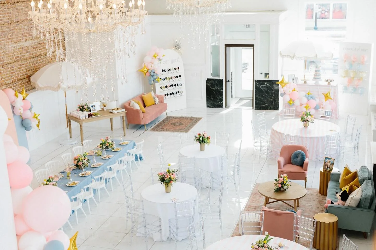 Styled bridal shower setup at The Treasury event venue in Delavan Wisconsin featuring chandeliers, exposed brick walls, and pastel event decor.