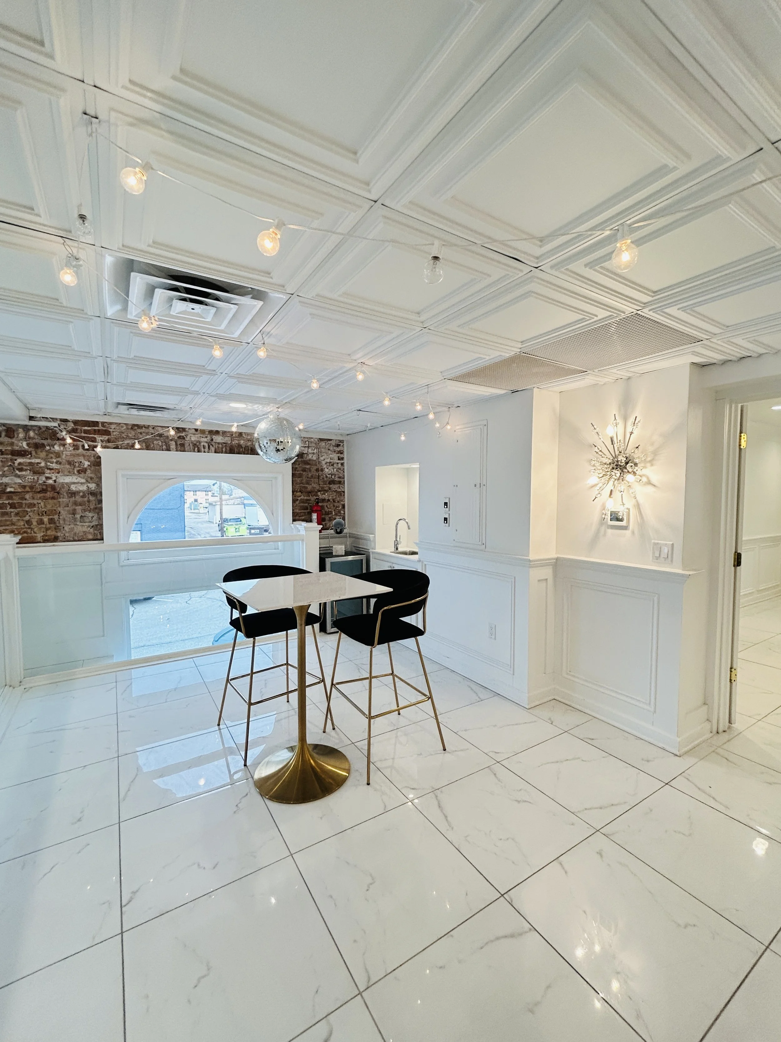 Cocktail lounge space with marble floors and string lights at The Treasury wedding venue in Delavan Wisconsin