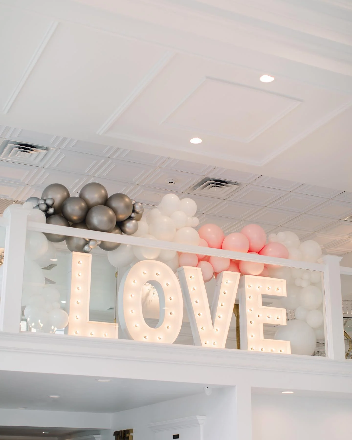 Illuminated LOVE sign and balloon installation at The Treasury wedding venue reception space in Delavan Wisconsin