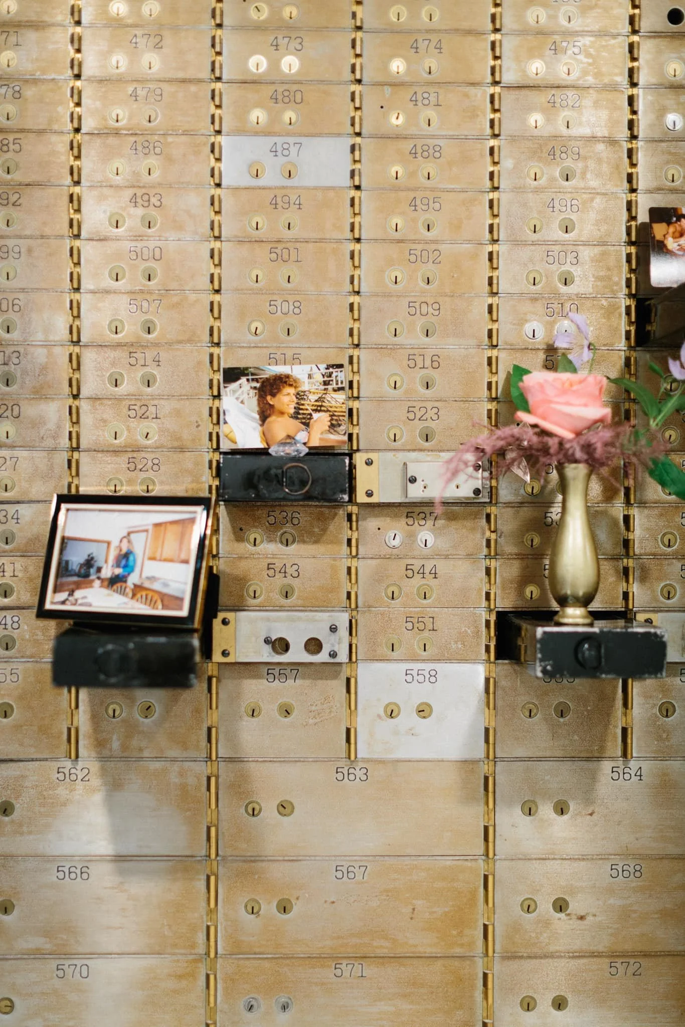 Historic safety deposit boxes inside The Treasury wedding venue in Delavan Wisconsin styled with photos and flowers.