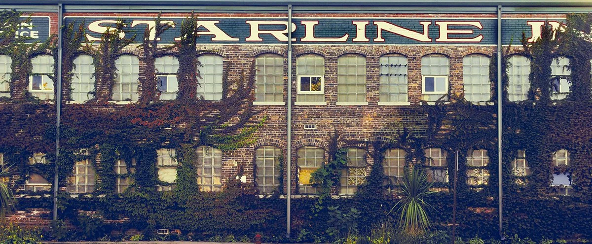 Historic Starline Factory brick building with large painted sign and ivy-covered facade in Harvard Illinois