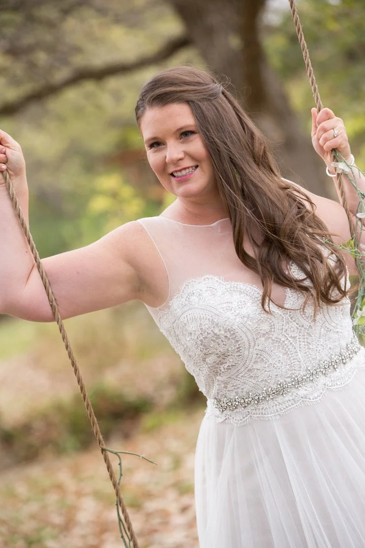 A rpoe swing hung from a large tree makes a beautiful location for the brides picture.