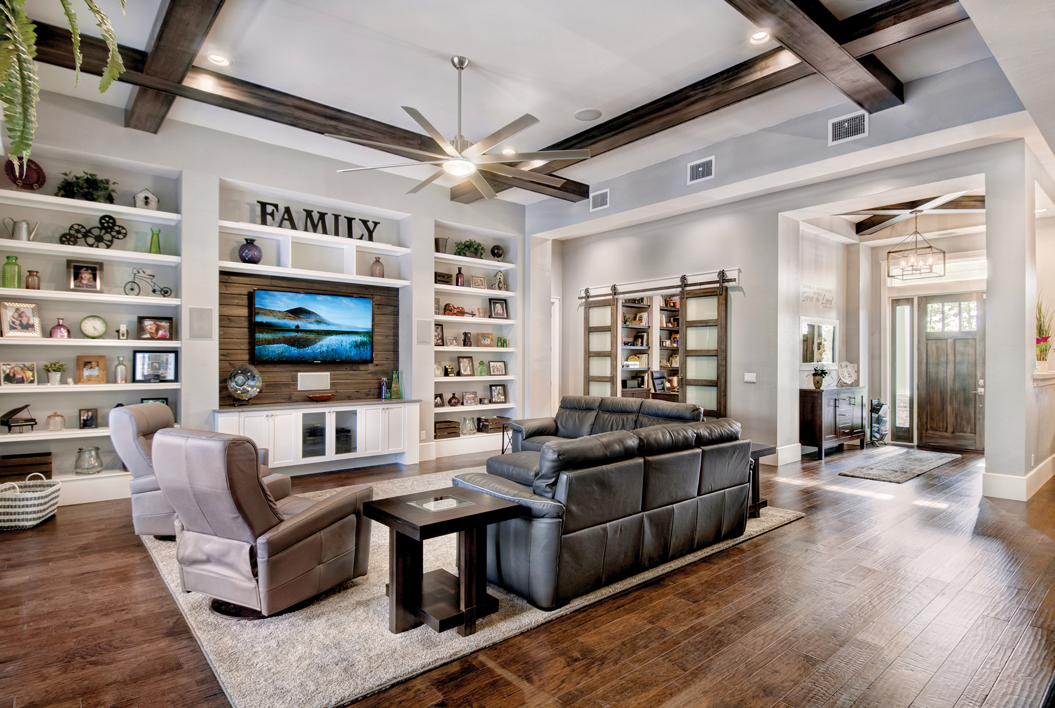  The focal point of the comfortable great room is a set of built-ins with a repurposed wood accent. “We were able to take some of the leftover wood from the ceilings on the lanai and use it in the great room,” says Sater. “It’s so much better to look