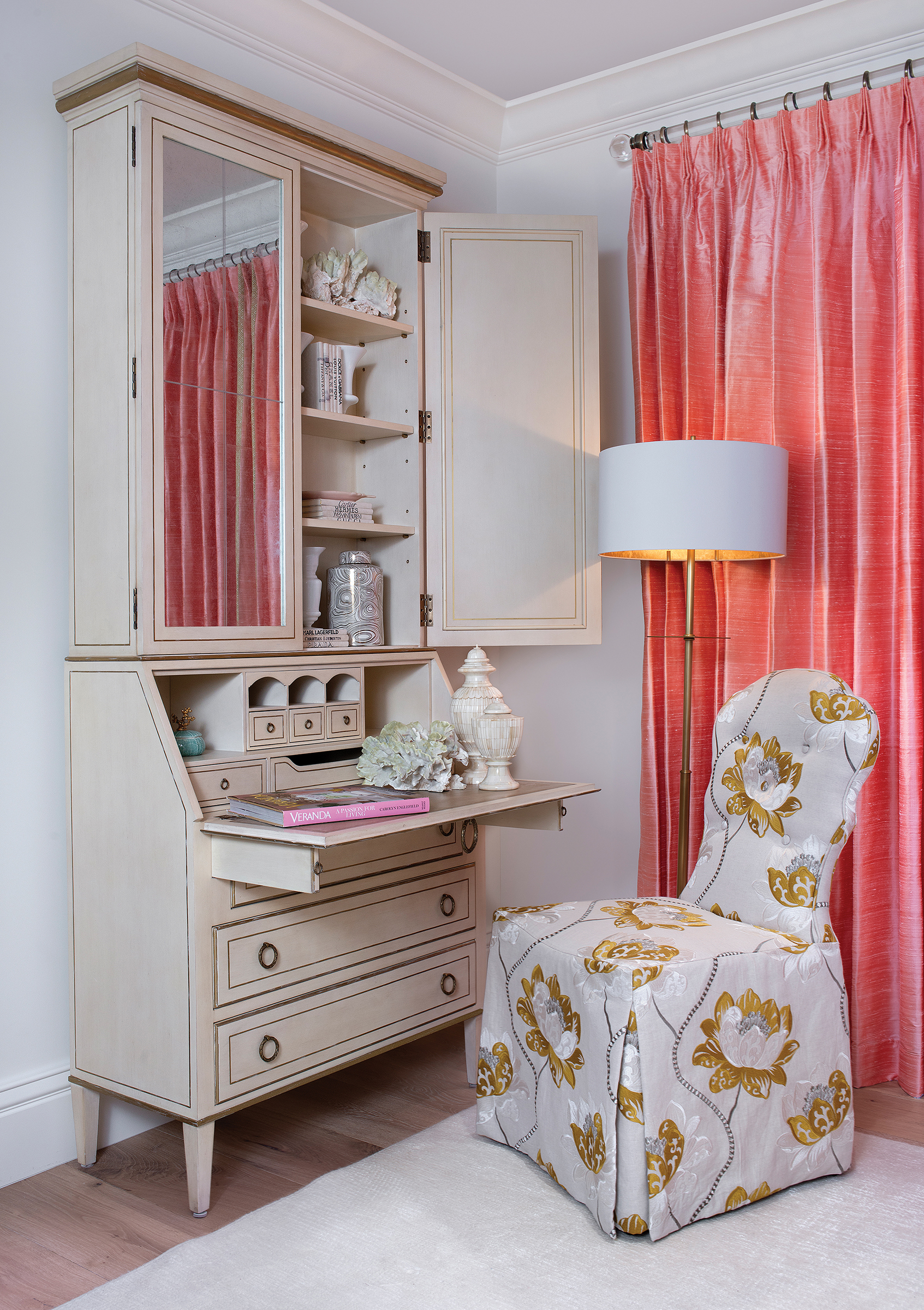  The Leif secretary desk with an Antique Linen finish is a staple of August’s line. An Arden Court chair with imported fabric completes this cozy workspace. French doors dressed in coral draperies fabricated by Statewide Window Treatments open onto t