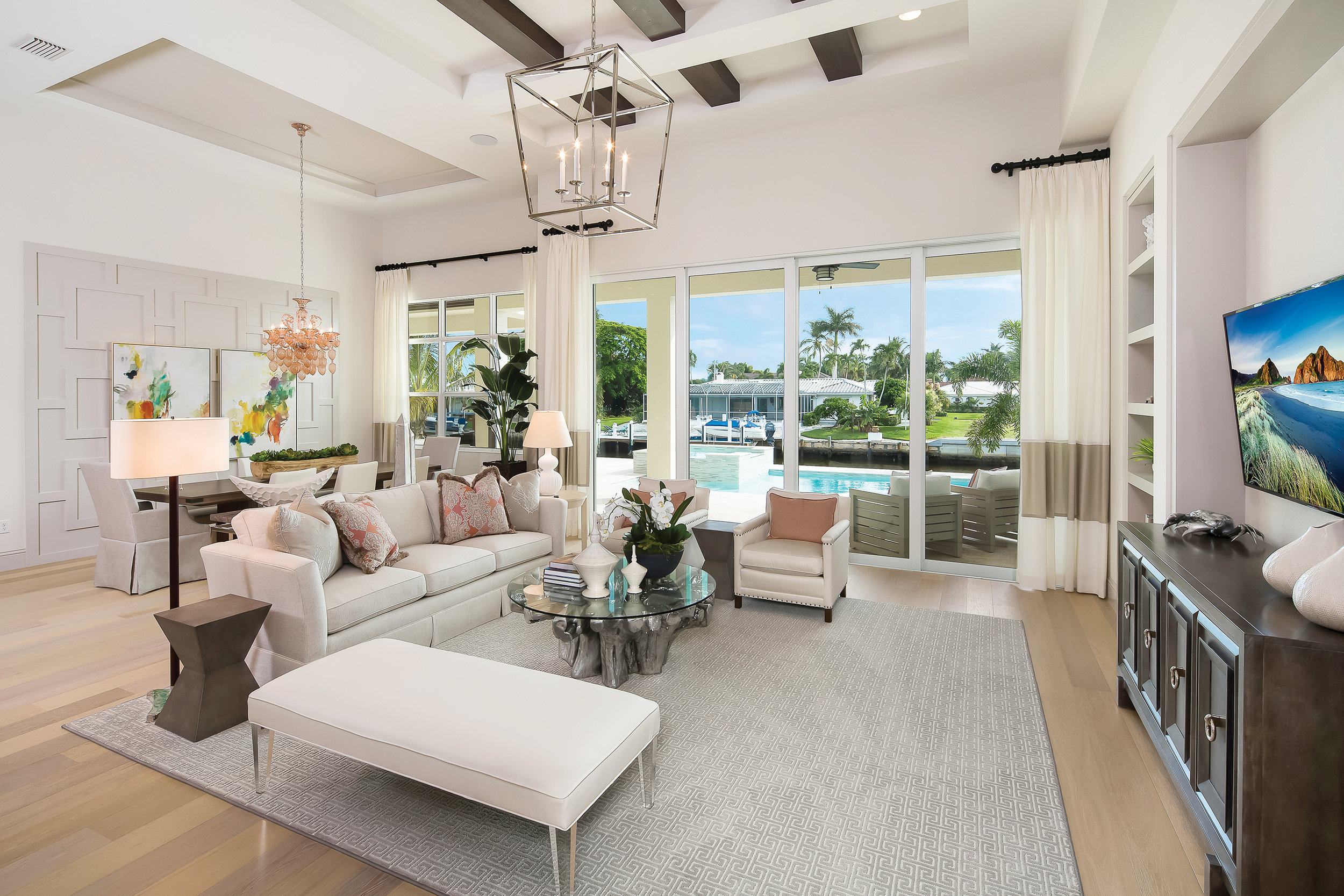  Inside, the home is open and breezy. Designer Daniel Kilgore of Soco Interiors chose light colors accented by pops of coral and dusty pink for the main areas of the home. The addition of dark wood finishes through accent pieces like side tables and 