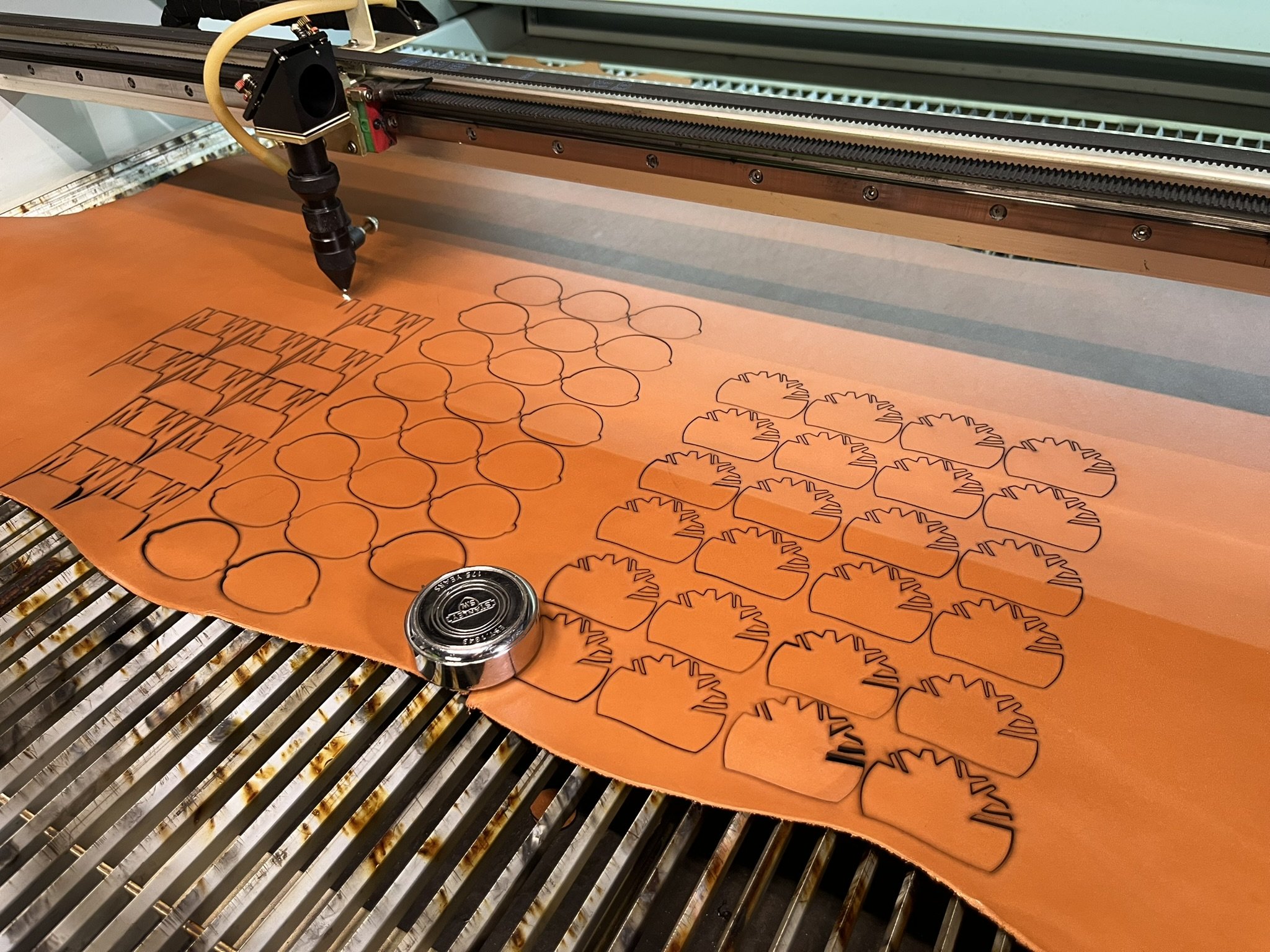 CO₂ laser cutting leather shapes for hardware and product applications.