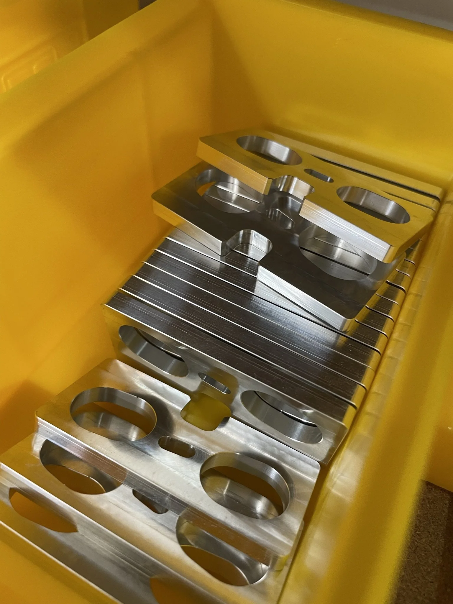 Simple CNC-milled components produced in a repeatable process, prepared and waiting to be shipped.