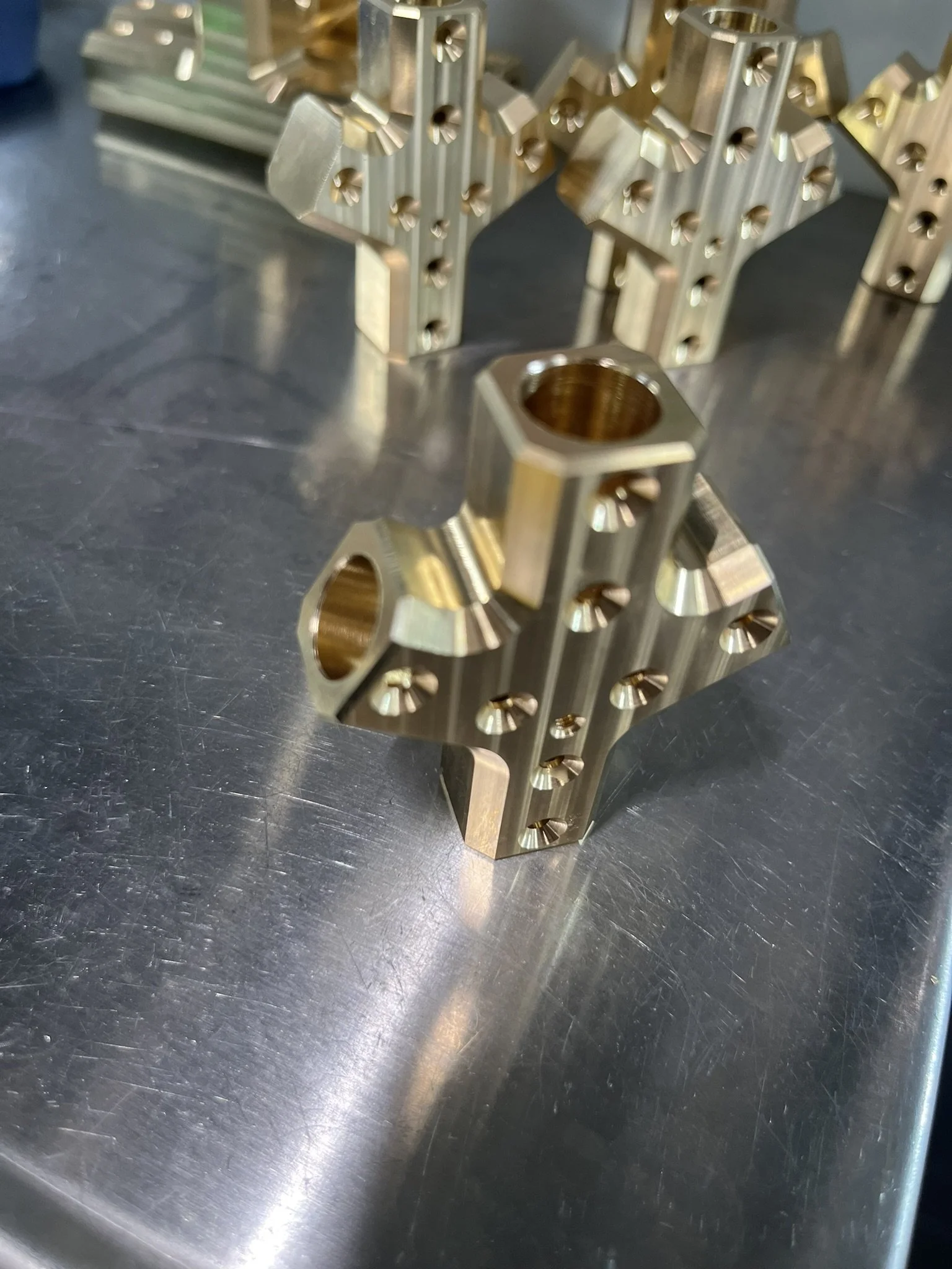 Complex brass lighting connector component produced through multiple CNC milling operations to achieve the required geometry and features.