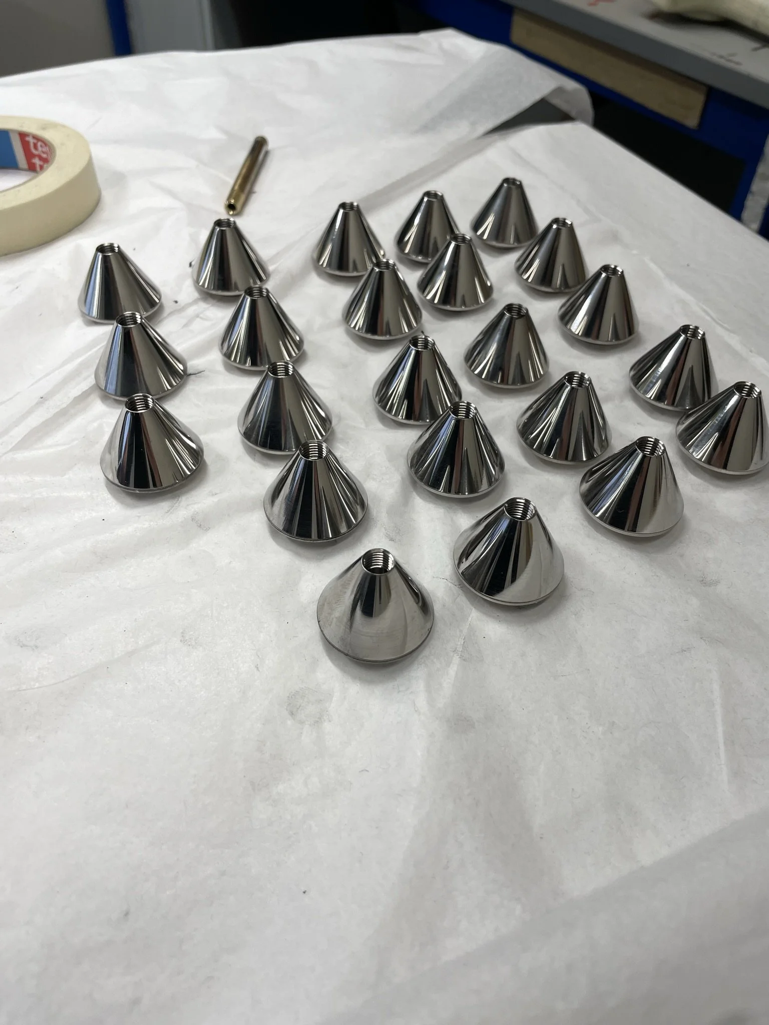 Small conical component CNC-turned with an internal threaded feature along the centre.