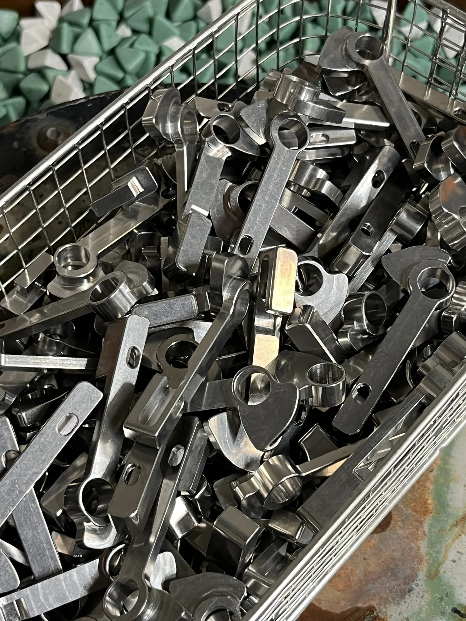 CNC-milled components processed in a vibratory tumbler to remove burrs and achieve a uniform surface finish.