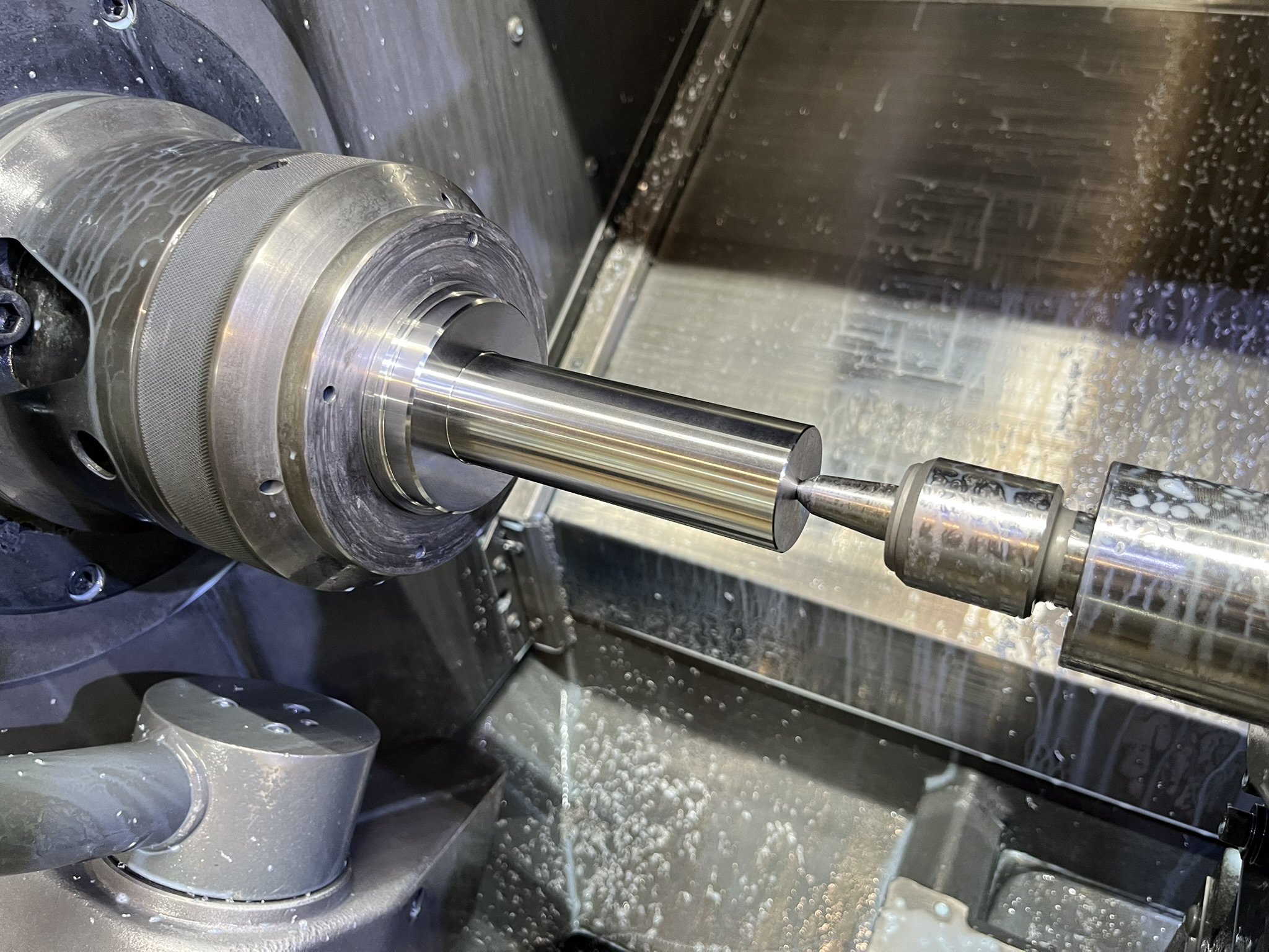 Stainless steel component held with tailstock in CNC lathe at Karpas Engineering